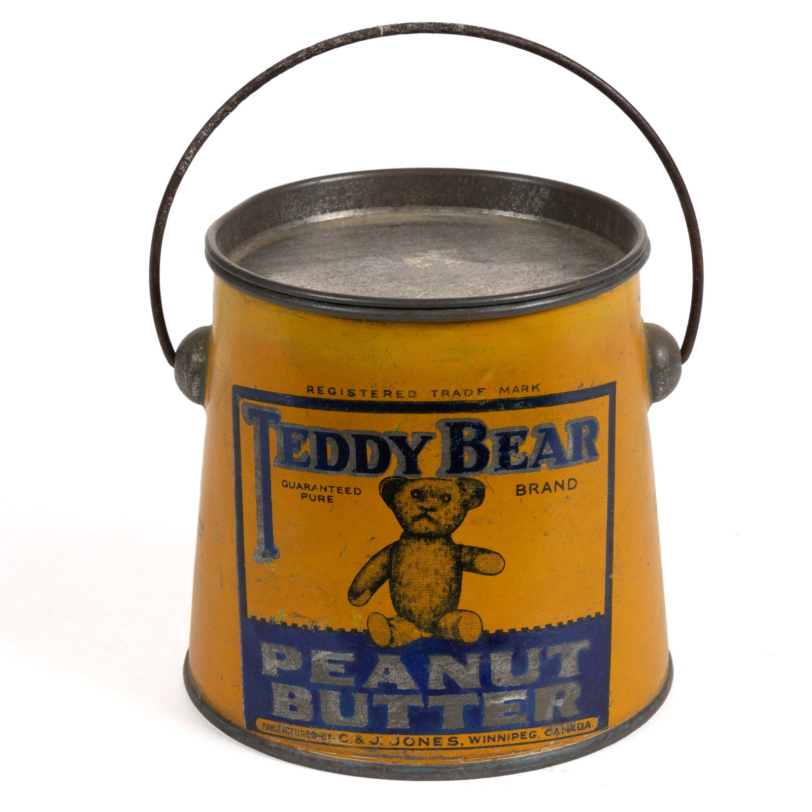 C. & J. JONES, WINNIPEG CANADA LITHOGRAPHED "TEDDY BEAR" ONE POUND PEANUT BUTTER TIN: C. & J. JONES, WINNIPEG CANADA LITHOGRAPHED "TEDDY BEAR" ONE POUND PEANUT BUTTER TIN, mustard yellow ground with dark blue lettering and shaded black bear, slightly tapered form, bail