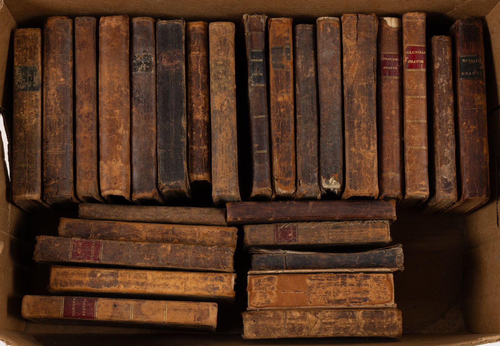 ANTIQUARIAN LEATHER EDUCATIONAL SCHOOL VOLUMES, LOT OF 27: ANTIQUARIAN LEATHER EDUCATIONAL SCHOOL VOLUMES, LOT OF 27, including (1) Green, Daboll's Schoolmaster's Assistant ... Arithmetic, 1825; (2) Cobb, Cobb's Juvenile Reader, No.