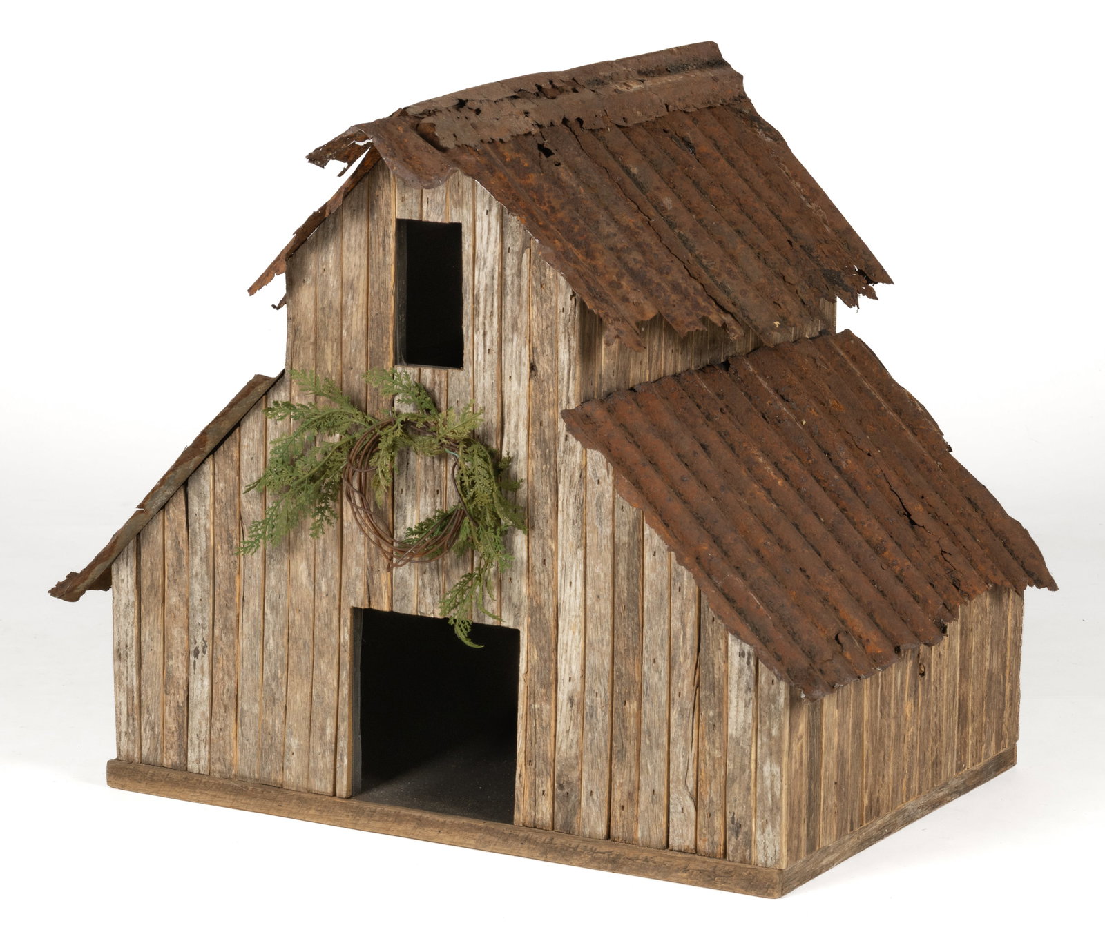 AMERICAN FOLK ART DECORATIVE MINIATURE BARN: AMERICAN FOLK ART DECORATIVE MINIATURE BARN, featuring a two-level pitched repurposed rusted tin roof over a rustic wood miniature clapboard, all mounted to a plywood base. Second half 20th centu