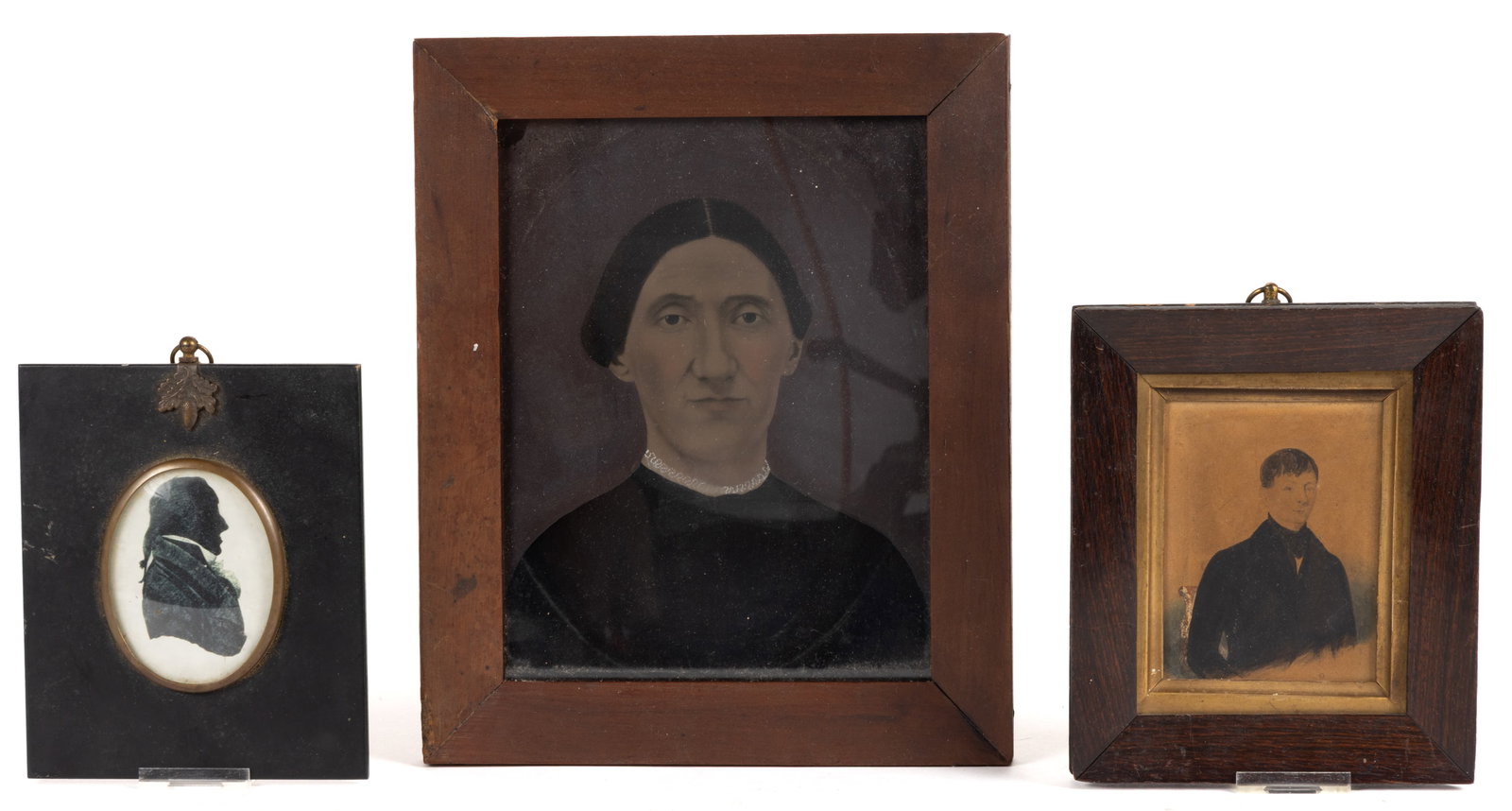 ASSORTED MINIATURE PORTRAITS AND SILHOUETTES, LOT OF THREE: ASSORTED MINIATURE PORTRAITS AND SILHOUETTES, LOT OF THREE, comprising a likely British watercolor portrait of a young man in a black suit and sitting in a chair, set in a rosewood-veneered frame