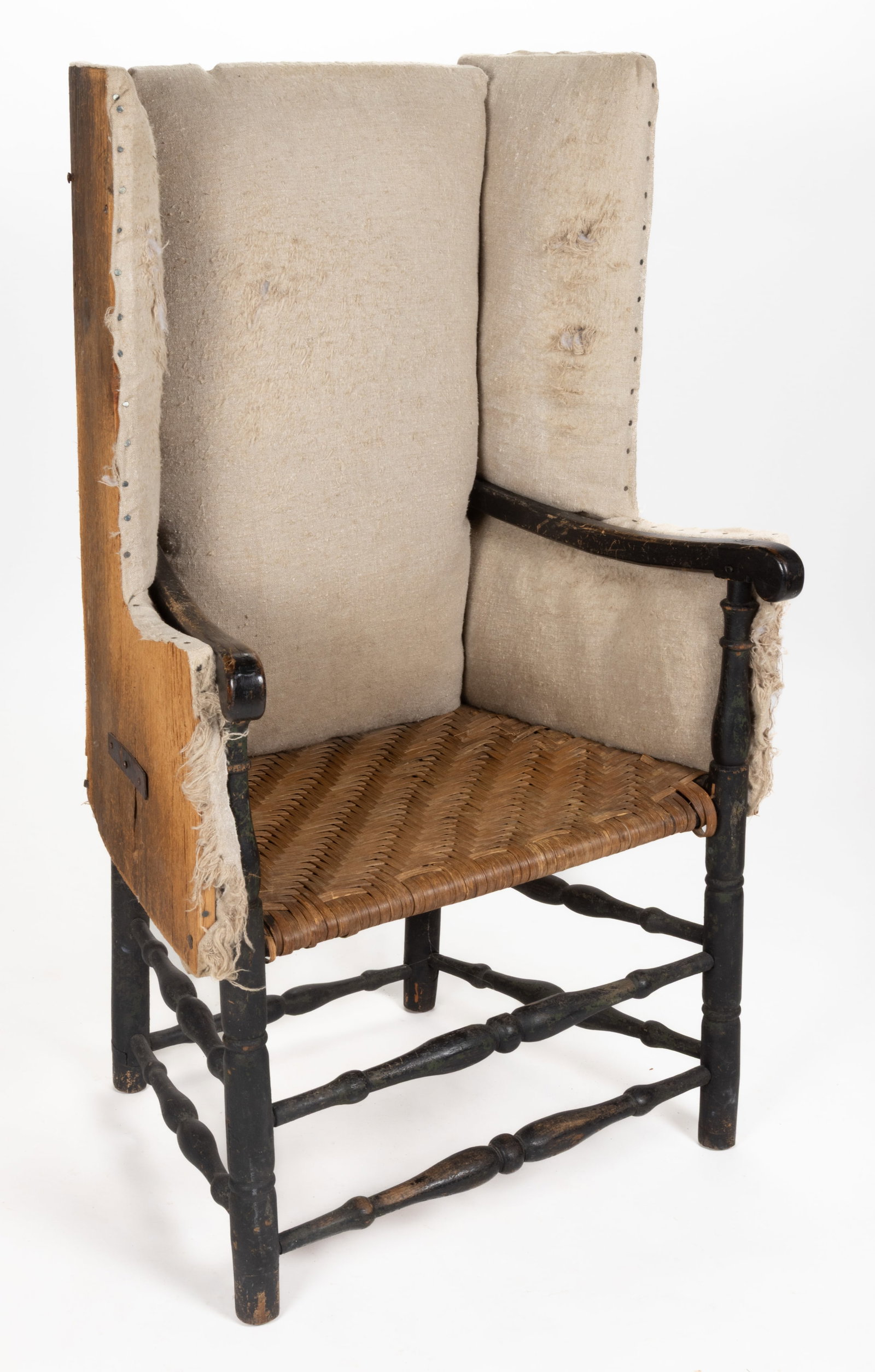 NEW ENGLAND PAINTED HOMESPUN-UPHOLSTERED MAKE-DO FIRESIDE ARMCHAIR: NEW ENGLAND PAINTED HOMESPUN-UPHOLSTERED MAKE-DO FIRESIDE ARMCHAIR, originally a bannister back armchair, featuring a rectangular back flanked by shaped wings over shaped arms on turned front posts an