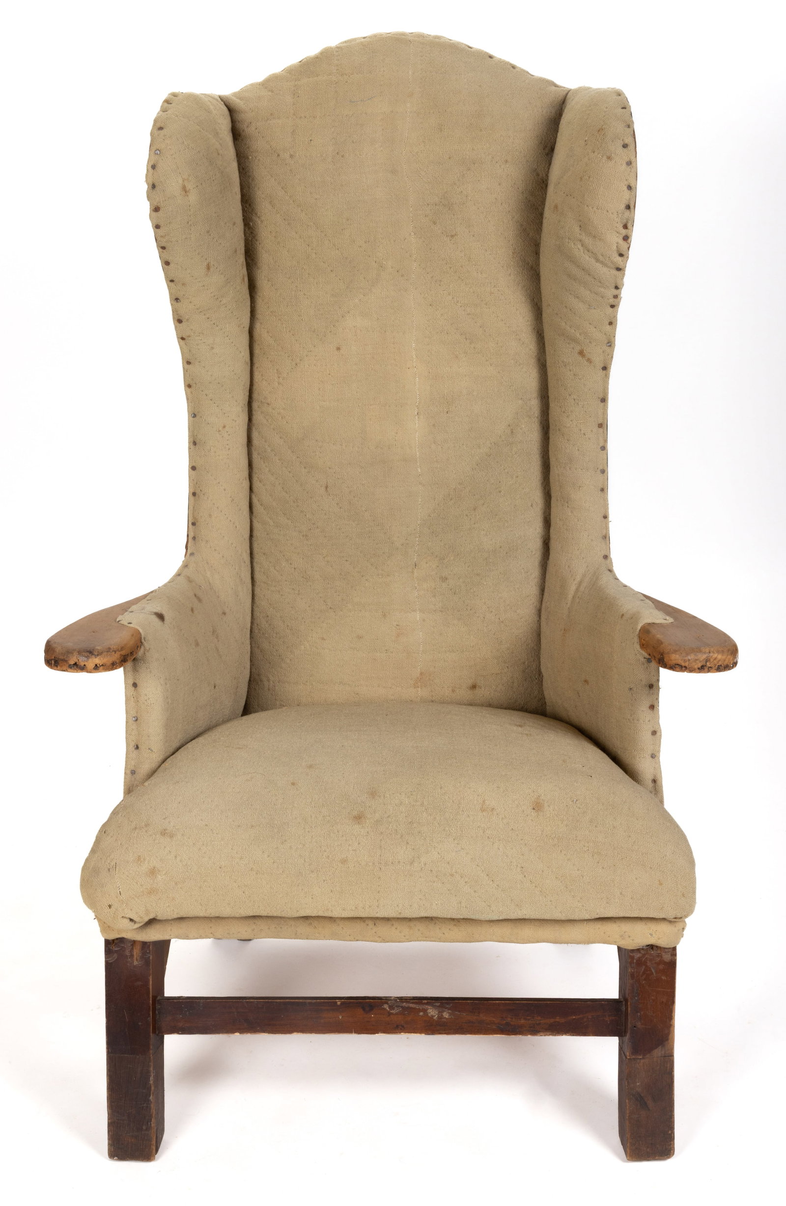 NEW ENGLAND HOMESPUN-UPHOLSTERED MAKE-DO FIRESIDE ARMCHAIR: NEW ENGLAND HOMESPUN-UPHOLSTERED MAKE-DO FIRESIDE ARMCHAIR, featuring an arched back flanked by shaped canted wings over shaped arms and a trapezoidal seat, the whole supported by square legs connecte