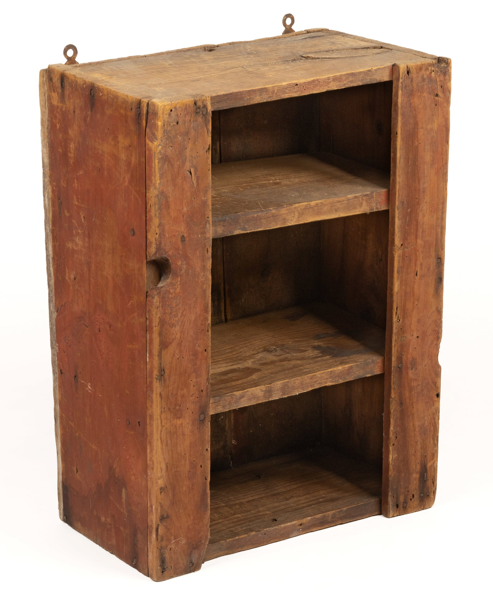NEW ENGLAND PAINTED PINE HANGING WALL SHELF: NEW ENGLAND PAINTED PINE HANGING WALL SHELF, nailed construction, rectangular form with three fixed shelves. Retains an early, possibly original red-washed surface. Mid 19th century. 23 3/4" HOA,