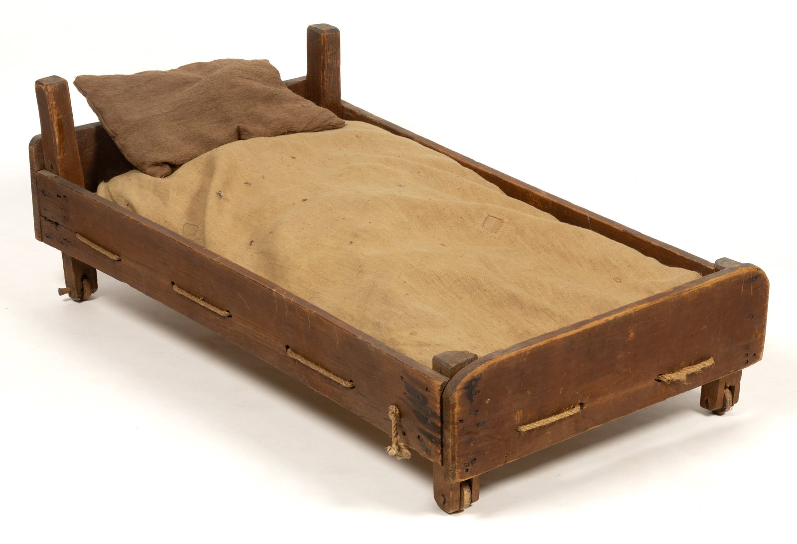 AMERICAN PAINTED PINE CHILD'S TRUNDLE BED: AMERICAN PAINTED PINE CHILD'S TRUNDLE BED, nailed construction, featuring four slightly-canted corner posts connecting four sides of the bed, each post with a wheel on the base. Retains an early r