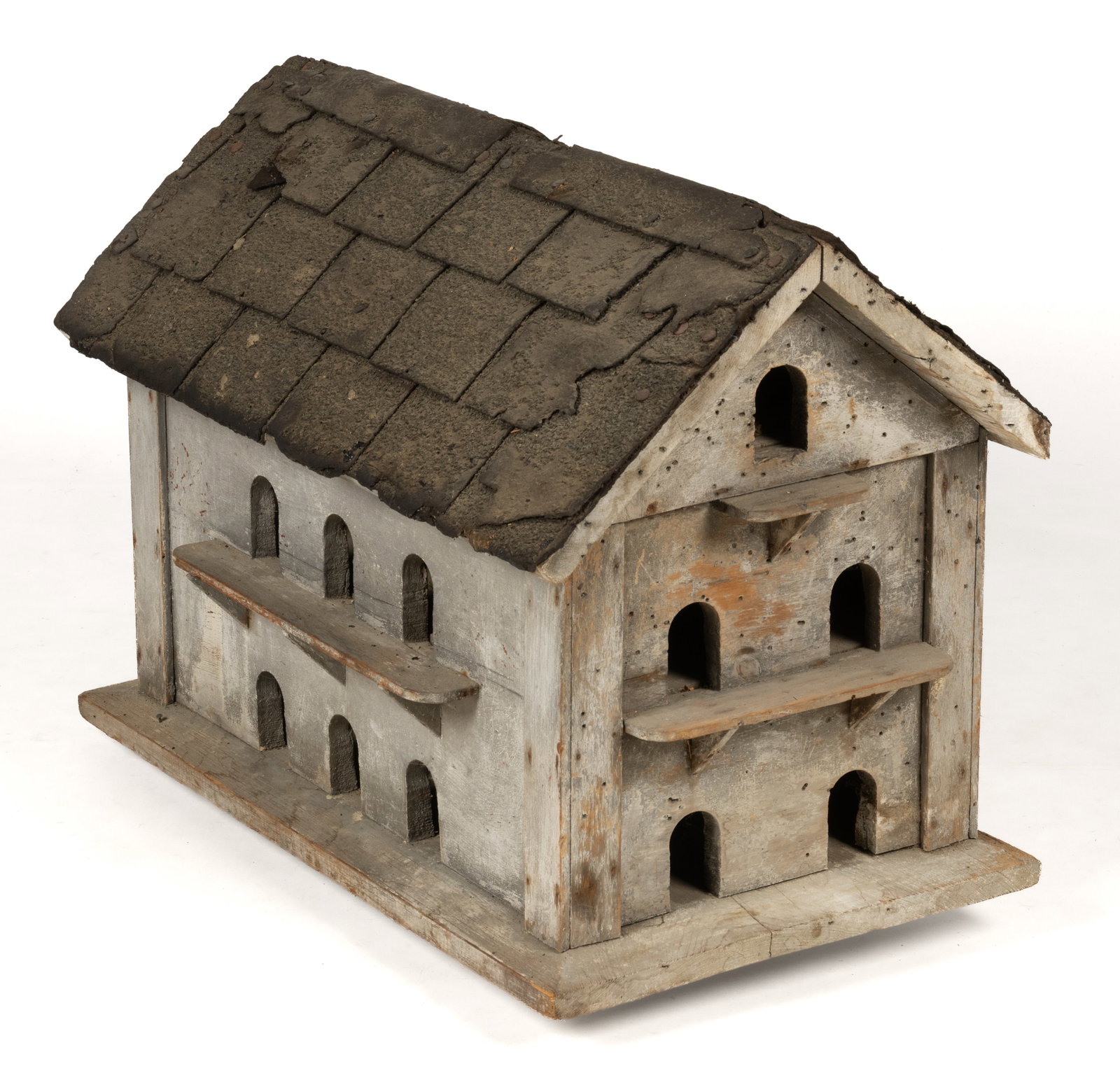 AMERICAN FOLK ART PAINTED PINE MARTIN / BIRD HOUSE: AMERICAN FOLK ART PAINTED PINE MARTIN / BIRD HOUSE, nailed-construction, in typical three-level rectangular form with a pitched roof covered in asphalt shingles, the whole on a plank base with