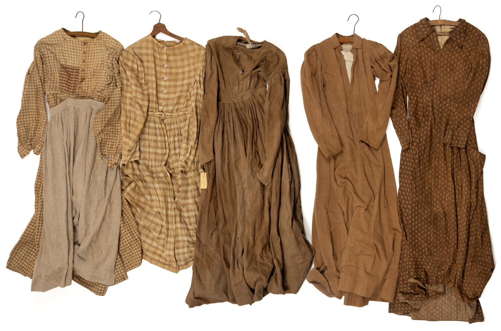 ANTIQUE / VINTAGE LADY'S DRESSES, LOT OF FIVE: ANTIQUE / VINTAGE LADY'S DRESSES, LOT OF FIVE, hand- and machine-stitched, each having long sleeves and button closures; comprising one made of a floral print fabric; and four with brown / tan pla