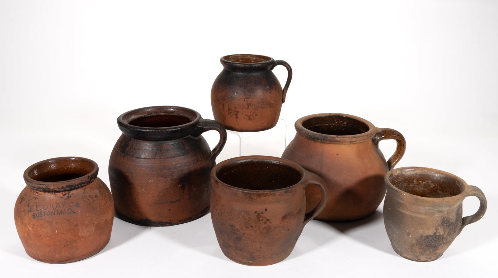 AMERICAN EARTHENWARE / REDWARE BEAN POTS, LOT OF SIX: AMERICAN EARTHENWARE / REDWARE BEAN POTS, LOT OF SIX, each having single lead-glazed interior, comprising one stamped "E.E. GRAY. CO. / BOSTON MASS." to shoulder and five with applied strap 