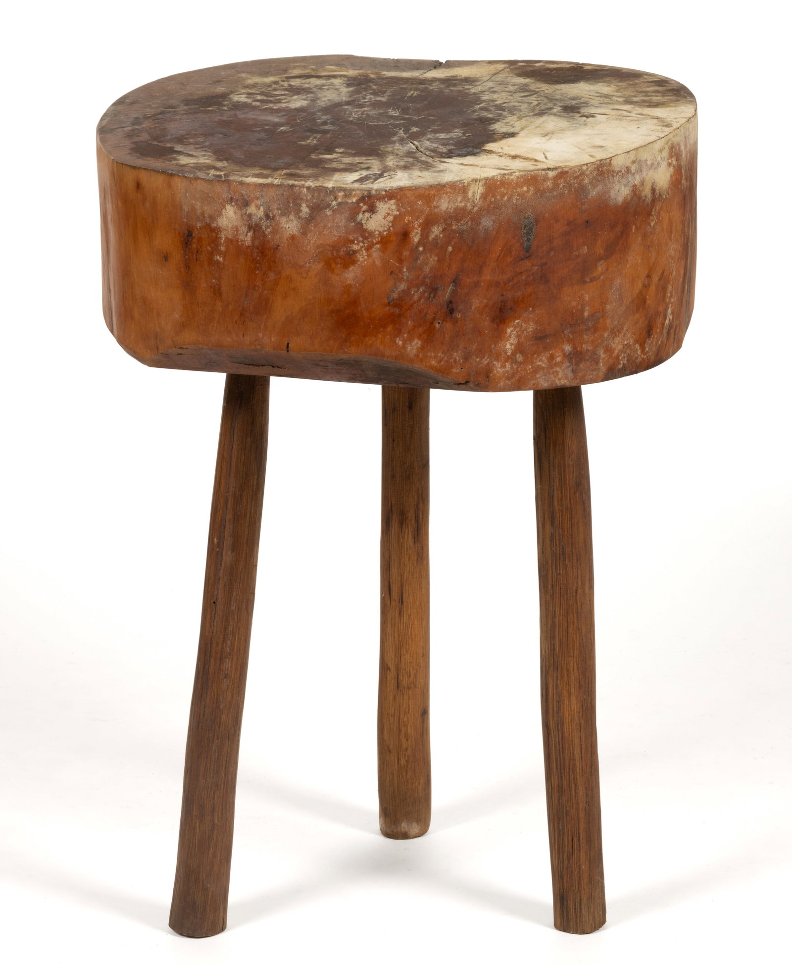 AMERICAN VERNACULAR CHOPPING BLOCK: AMERICAN VERNACULAR CHOPPING BLOCK, probably sycamore and oak or hickory, the thick block of rounded naturalistic form supported by three legs. 19th century. 24 3/4" HOA, 19" x 17 3/4" 