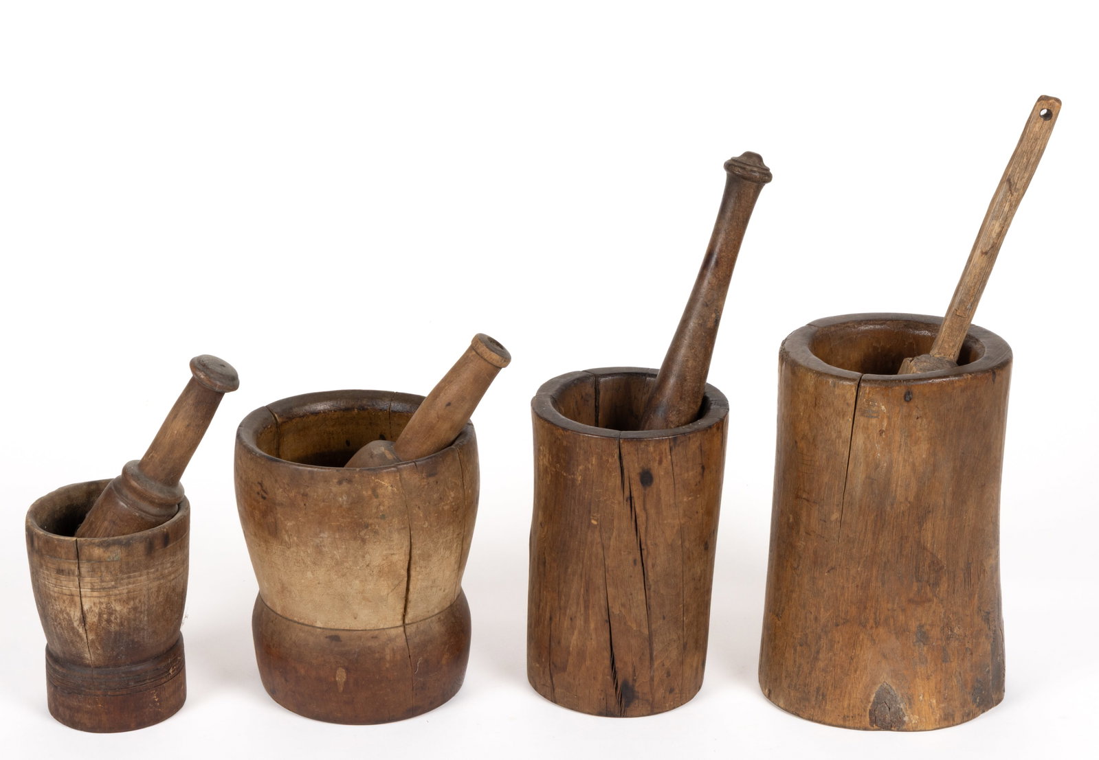 ASSORTED TURNED TREEN MORTARS AND PESTLES, LOT OF FOUR: ASSORTED TURNED TREEN MORTARS AND PESTLES, LOT OF FOUR, each of a similar turned form with an associates pestle, each retaining the original dry or lightly finished surface. 19th century. Tallest mort