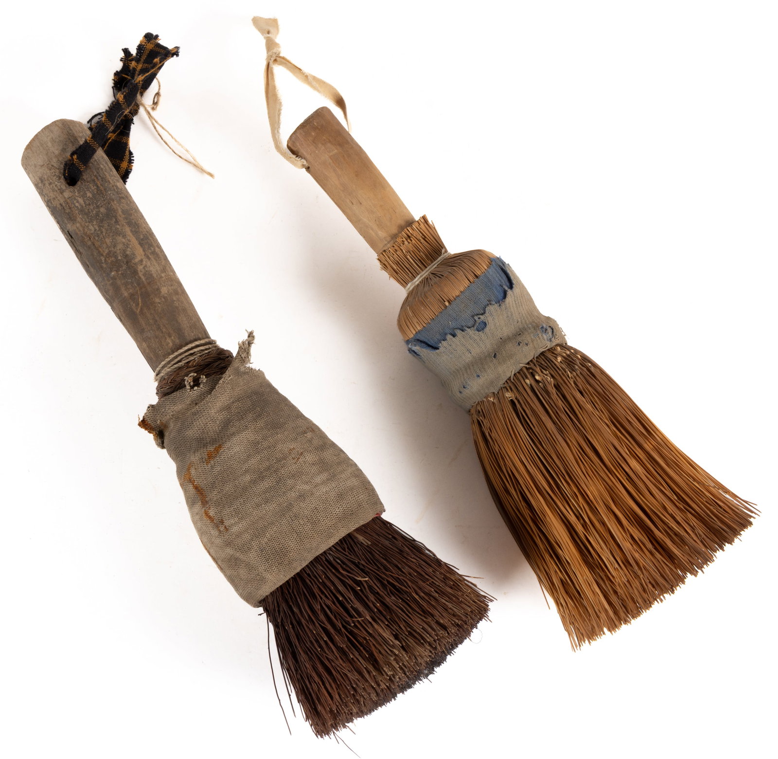 NEW ENGLAND DIMINUTIVE HEARTH / TABLE BROOMS, LOT OF TWO: NEW ENGLAND DIMINUTIVE HEARTH / TABLE BROOMS, LOT OF TWO, each having a shaven handle with one example having a worn dark painted surface, each with a broom corn or similar material for the