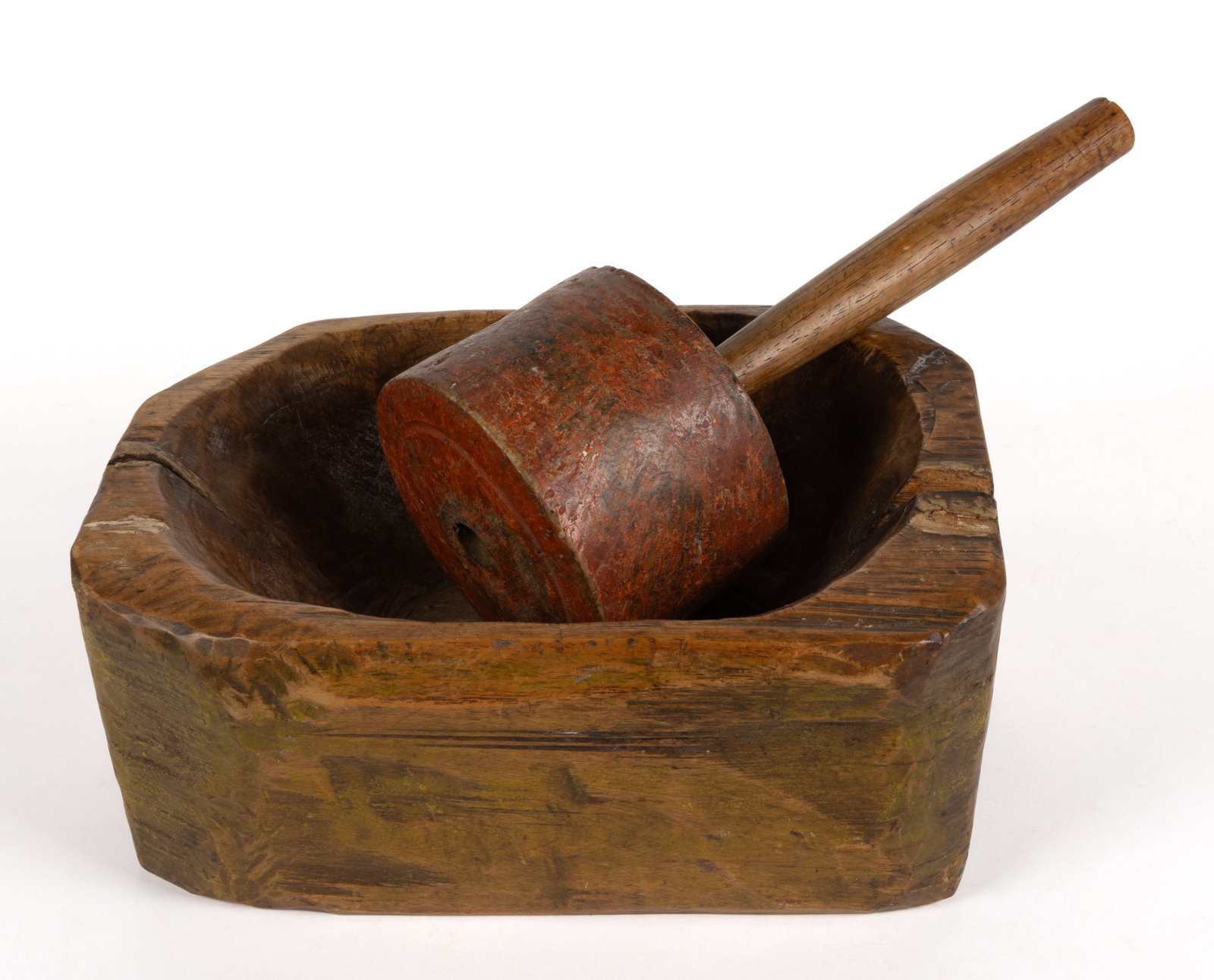 CARVED WOODEN MORTAR AND PESTLE: CARVED PAINTED WOODEN MORTAR AND PESTLE, mortar retains a worn mustard yellow/green painted surface, having a one-piece block construction with carved cavity; and a red painted
