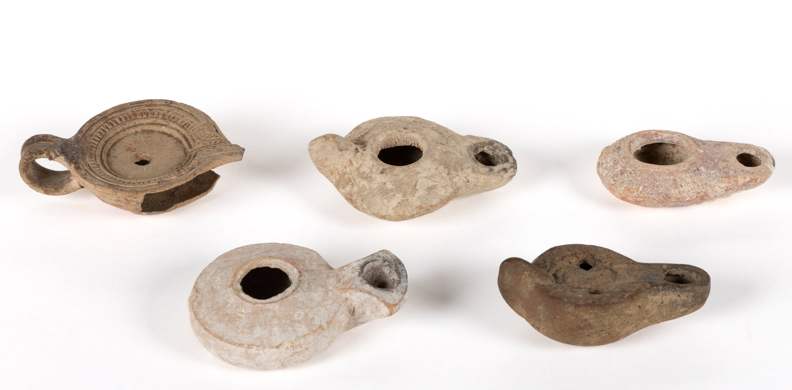 ASSORTED ANCIENT POTTERY / TERRACOTTA OIL LAMPS, LOT OF FIVE: ASSORTED ANCIENT POTTERY / TERRACOTTA OIL LAMPS, LOT OF FIVE, including an example with Byzantine/Islamic period attribution and having a carved shoulder; an example with Roman period attribution