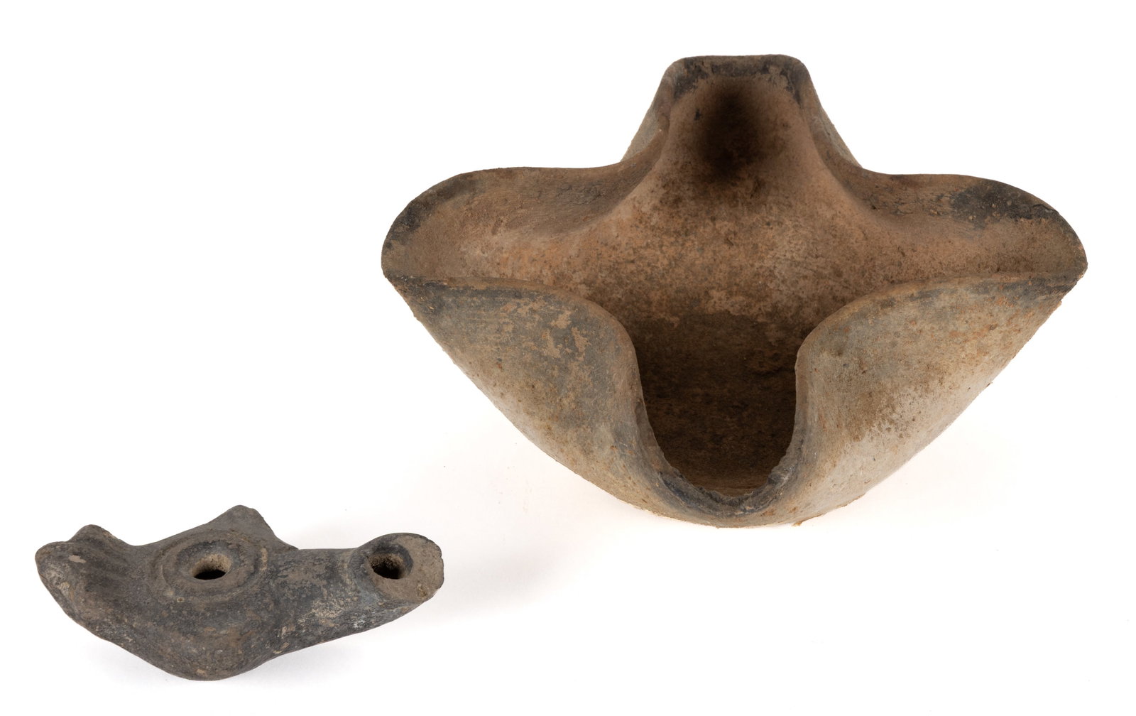 ASSORTED ANCIENT POTTERY / TERRACOTTA OIL LAMPS, LOT OF TWO: ASSORTED ANCIENT POTTERY / TERRACOTTA OIL LAMPS, LOT OF TWO, comprising an Iron Age period and Palestine attributed example, having a deep well and four channels with folded-in sides; and remaining a 
