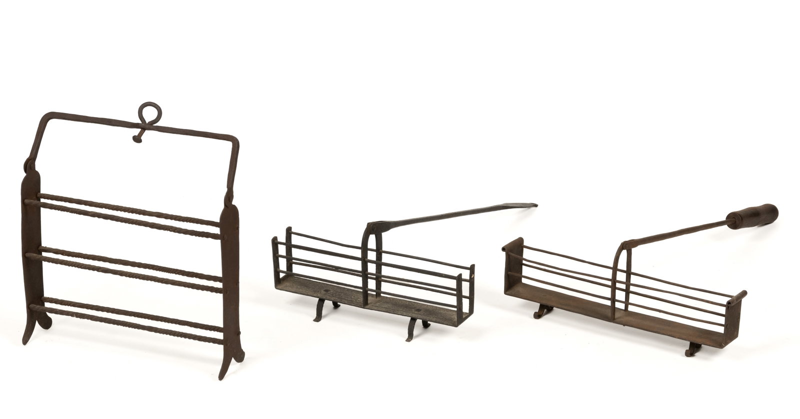 ASSORTED WROUGHT-IRON HEARTH AND FIREPLACE TOASTERS LOT OF THREE: ASSORTED WROUGHT-IRON HEARTH AND FIREPLACE TOASTERS LOT OF THREE, rectangular cage form with solid plate base and supported by two U-form feet including one with the tips curled, each having a hinged 