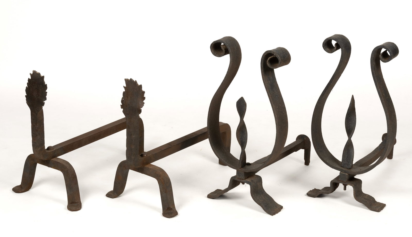ASSORTED ARTS AND CRAFTS STYLE IRON FIREPLACE ANDIRONS, LOT OF TWO PAIRS: ASSORTED ARTS AND CRAFTS STYLE IRON FIREPLACE ANDIRONS, LOT OF TWO PAIR, comprising of a pair with cut and jagged finials, heavy square-form billet bars and swayed legs; and remaining pair of Lyre-typ