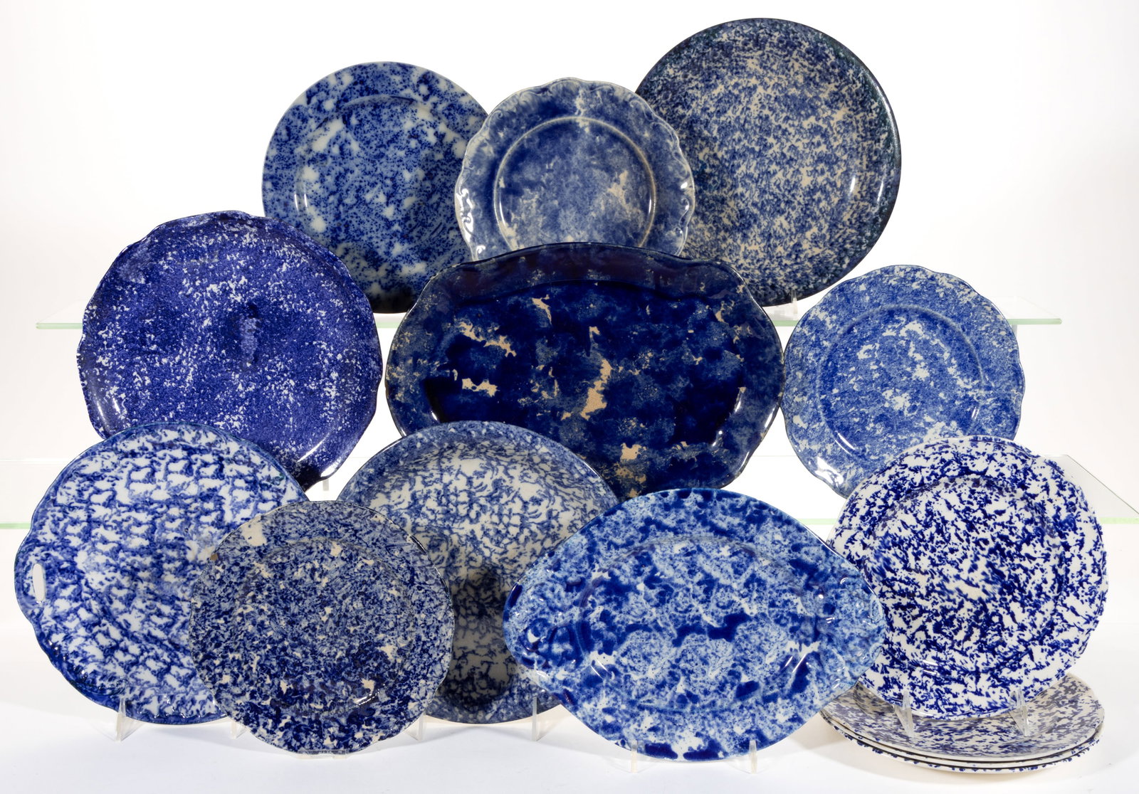 ASSORTED BLUE SPONGE-DECORATED CERAMIC TABLE ARTICLES, LOT OF 14: ASSORTED BLUE SPONGE-DECORATED CERAMIC TABLE ARTICLES, LOT OF 14, comprising an open-handled cake plate, a 13 1/2" x 9 1/8" platter, an 11 7/8" x 8 3/4" undertray, and eleven plate