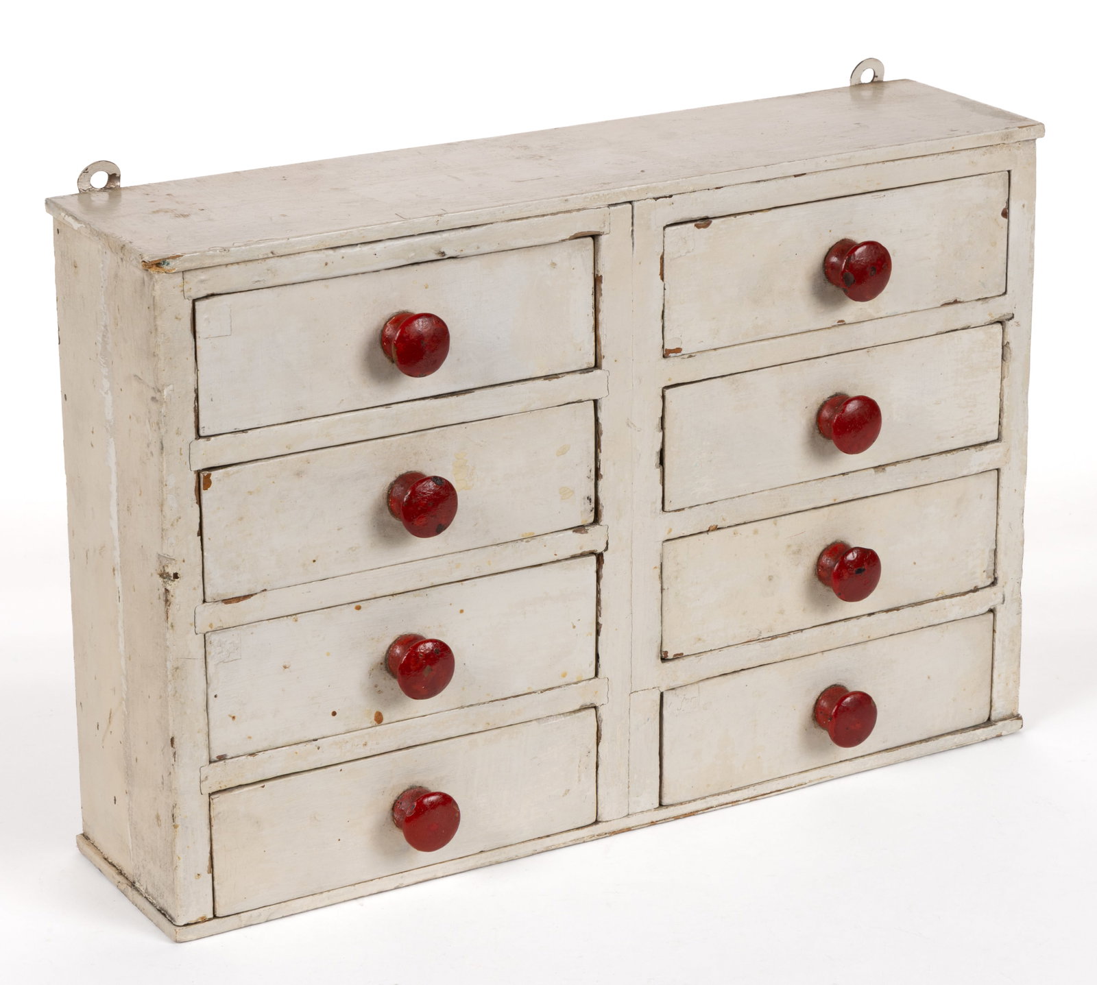 AMERICAN PAINTED POPLAR DIMINUTIVE HANGING SPICE CABINET: AMERICAN PAINTED POPLAR DIMINUTIVE HANGING SPICE CABINET, featuring a slightly-overhanging rectangular top over eight short drawers, each set with a turned knob, two later-added loops applied to the