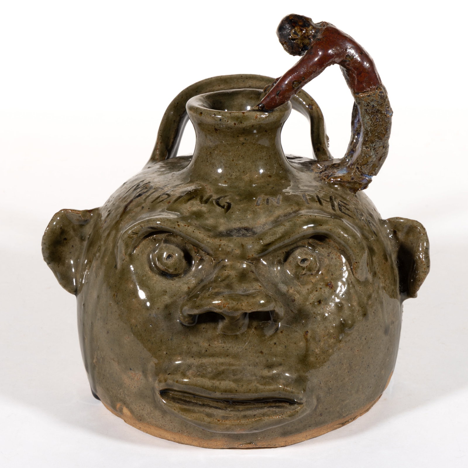 SIGNED "NED BERRY", ALABAMA / GEORGIA STONEWARE FACE JUG: SIGNED "NED BERRY", ALABAMA / GEORGIA STONEWARE FACE JUG, hand-modeled with beady eyes under a protruding brow ridge, a nose with wide nostrils, and a slightly open mouth, having a standing 
