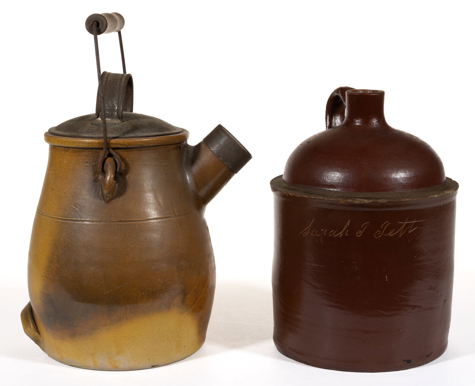 AMERICAN STONEWARE JUGS, LOT OF TWO: AMERICAN STONEWARE JUGS, LOT OF TWO, comprising an approximately one-gallon capacity example having reddish brown glaze, applied strap handle, and inscribed "Sarah J Jett" to front