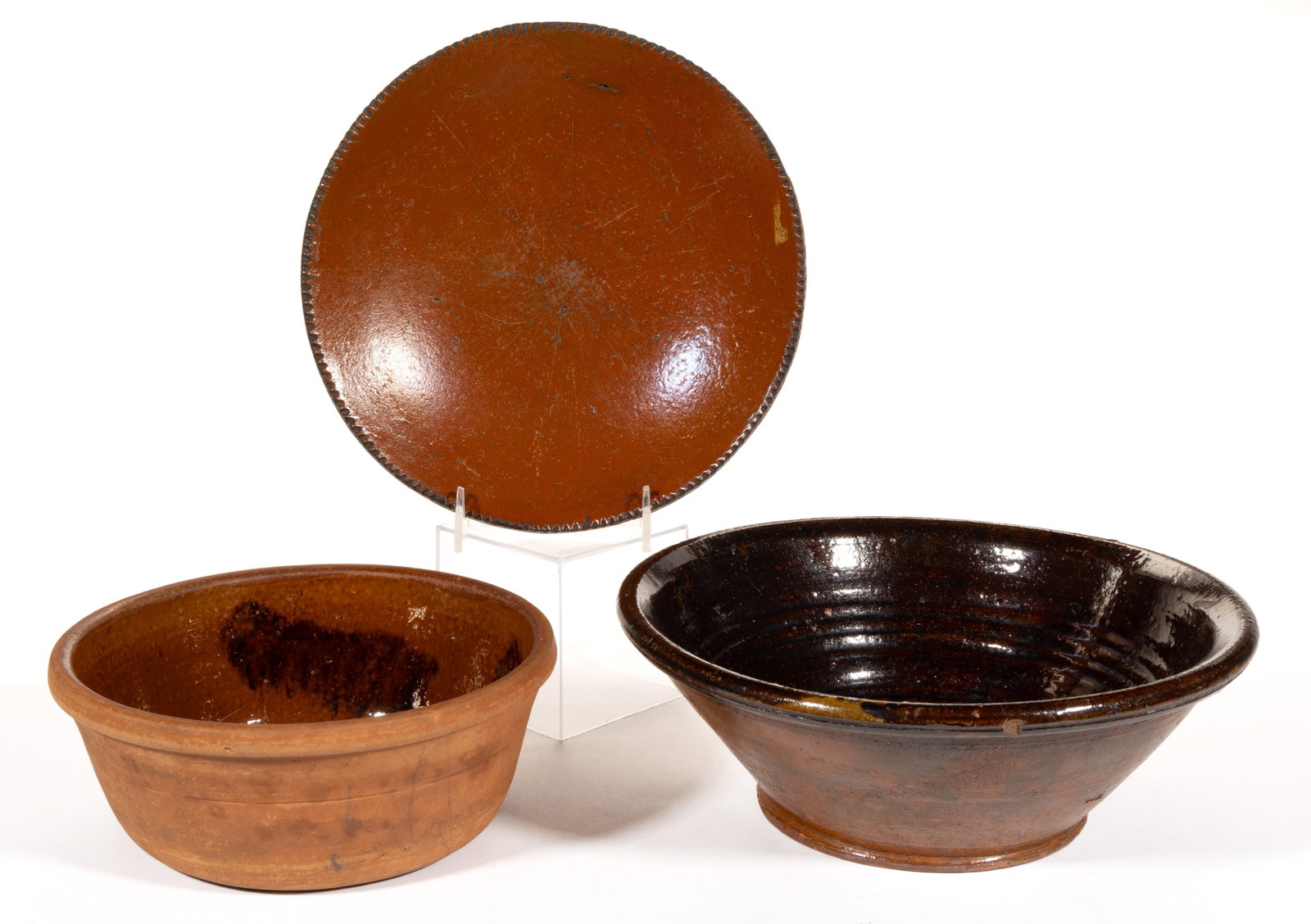 AMERICAN EARTHENWARE / REDWARE BOWLS / PANS, LOT OF THREE: AMERICAN EARTHENWARE / REDWARE BOWLS / PANS, LOT OF THREE, lead-glazed, comprising an 11 1/8" D conical-form example having additional manganese glaze to interior and two single-glazed examples