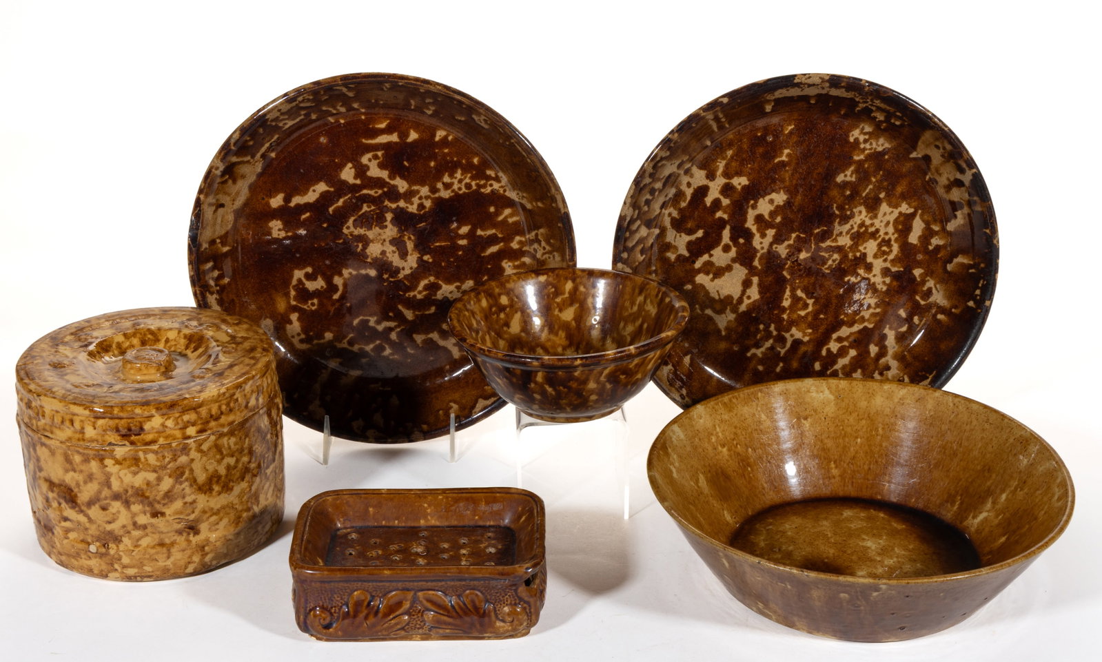 AMERICAN ROCKINGHAM-GLAZED POTTERY ARTICLES, LOT OF SIX: AMERICAN ROCKINGHAM-GLAZED POTTERY ARTICLES, LOT OF SIX, comprising a covered butter crock having relief peacock and fountain decoration, a rectangular soap dish with acanthus leaf decoration, a 6