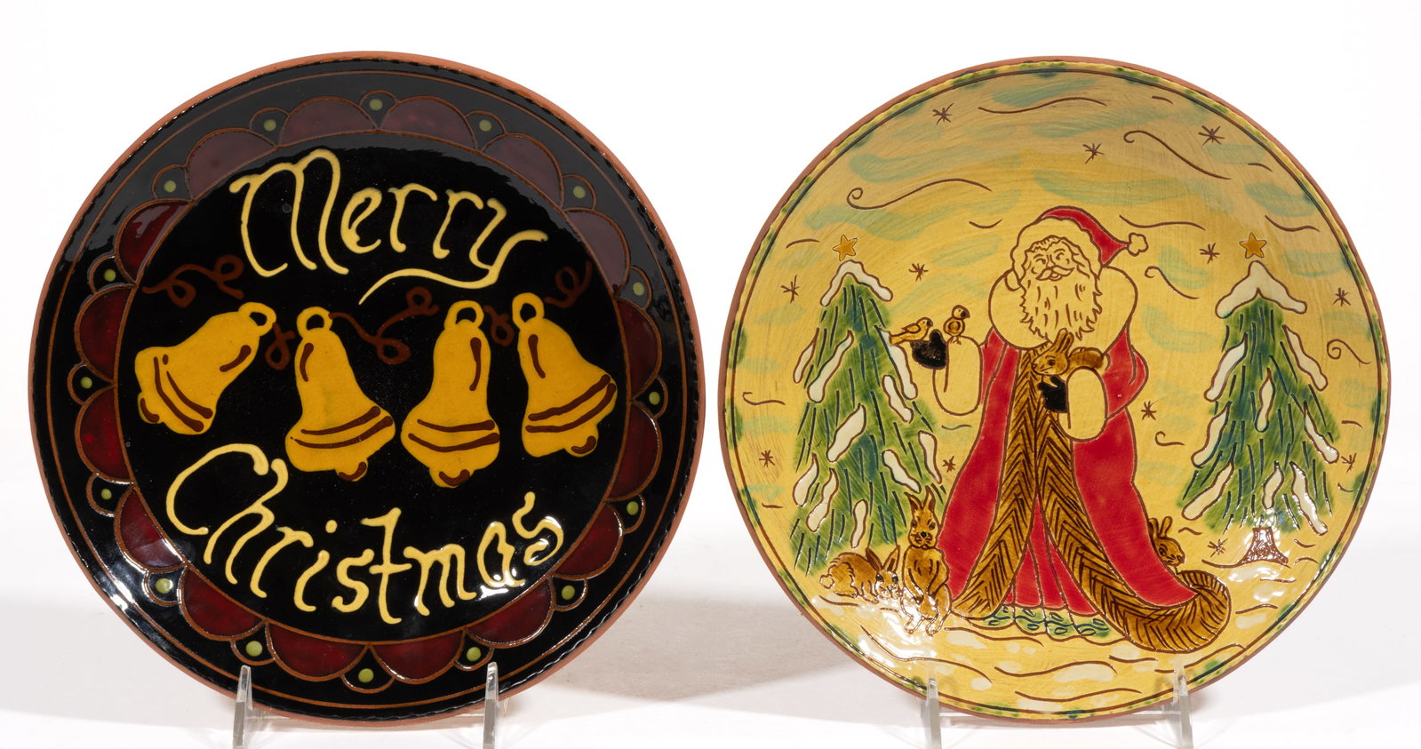 ROBESONIA, PENNSYLVANIA CONTEMPORARY SLIP-DECORATED HOLIDAY MOTIF EARTHENWARE / REDWARE PLATES, LOT: ROBESONIA, PENNSYLVANIA CONTEMPORARY SLIP-DECORATED HOLIDAY MOTIF EARTHENWARE / REDWARE PLATES, LOT OF TWO, each having polychrome decorations, comprising one example depicting Santa wearing a long