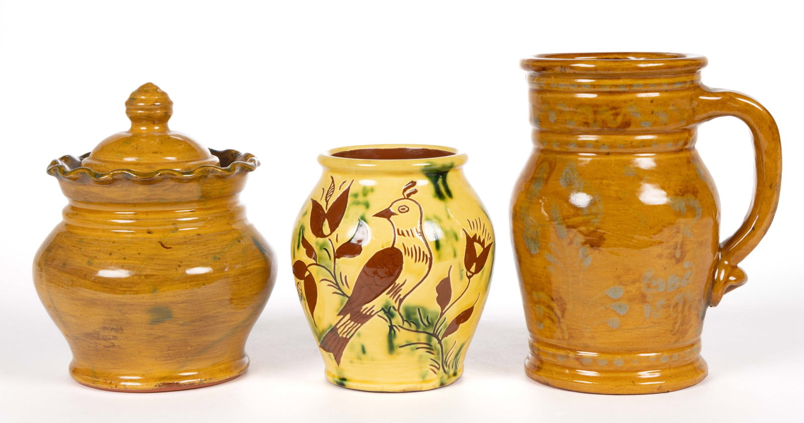 PENNSYLVANIA CONTEMPORARY EARTHENWARE / REDWARE ARTICLES, LOT OF THREE: PENNSYLVANIA CONTEMPORARY EARTHENWARE / REDWARE ARTICLES, LOT OF THREE, lead-glazed, comprising a yellow-slip jar featuring sgraffito-decorated bird and flower motif, incised "Breininger Pottery