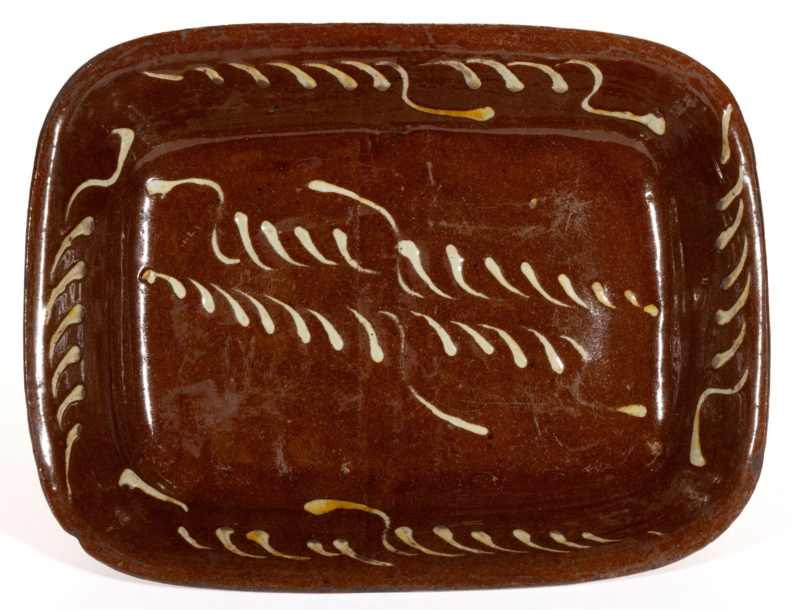 ENGLISH SLIP-DECORATED EARTHENWARE / REDWARE BAKING DISH: ENGLISH SLIP-DECORATED EARTHENWARE / REDWARE BAKING DISH, lead-glazed, rectangular form with yellow-slip teardrop designs. Probably Sunderland. Second half 19th century. 13 1/4" x 10 1/4".&n