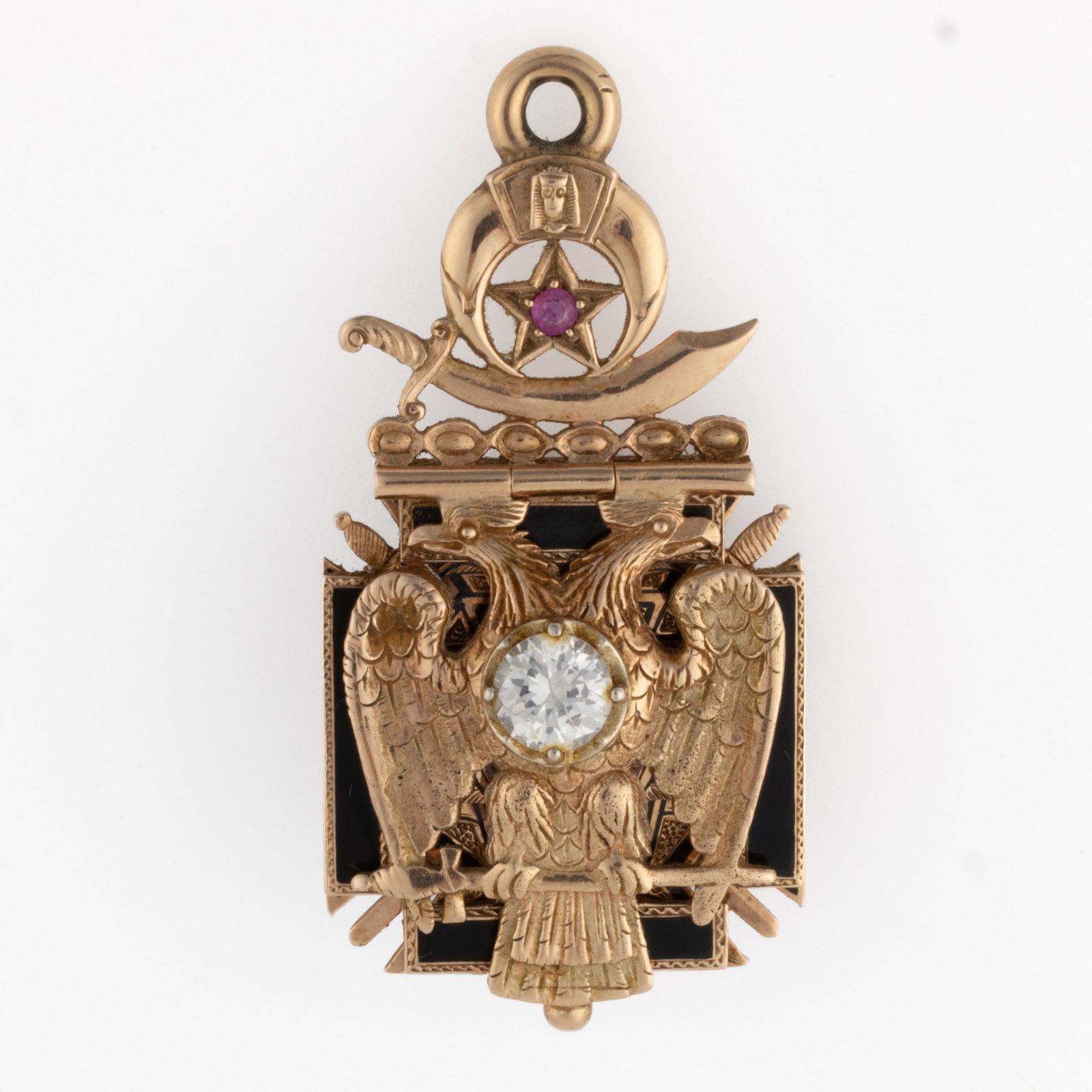 ANTIQUE 14K YELLOW GOLD, ENAMEL, AND STONE PENNSYLVANIA MASONIC WATCH FOB / PENDANT: ANTIQUE 14K YELLOW GOLD, ENAMEL, AND STONE PENNSYLVANIA MASONIC WATCH FOB / PENDANT, top with Shriner's symbols including a scimitar sword and a star set with a round-cut ruby, hinged form consist