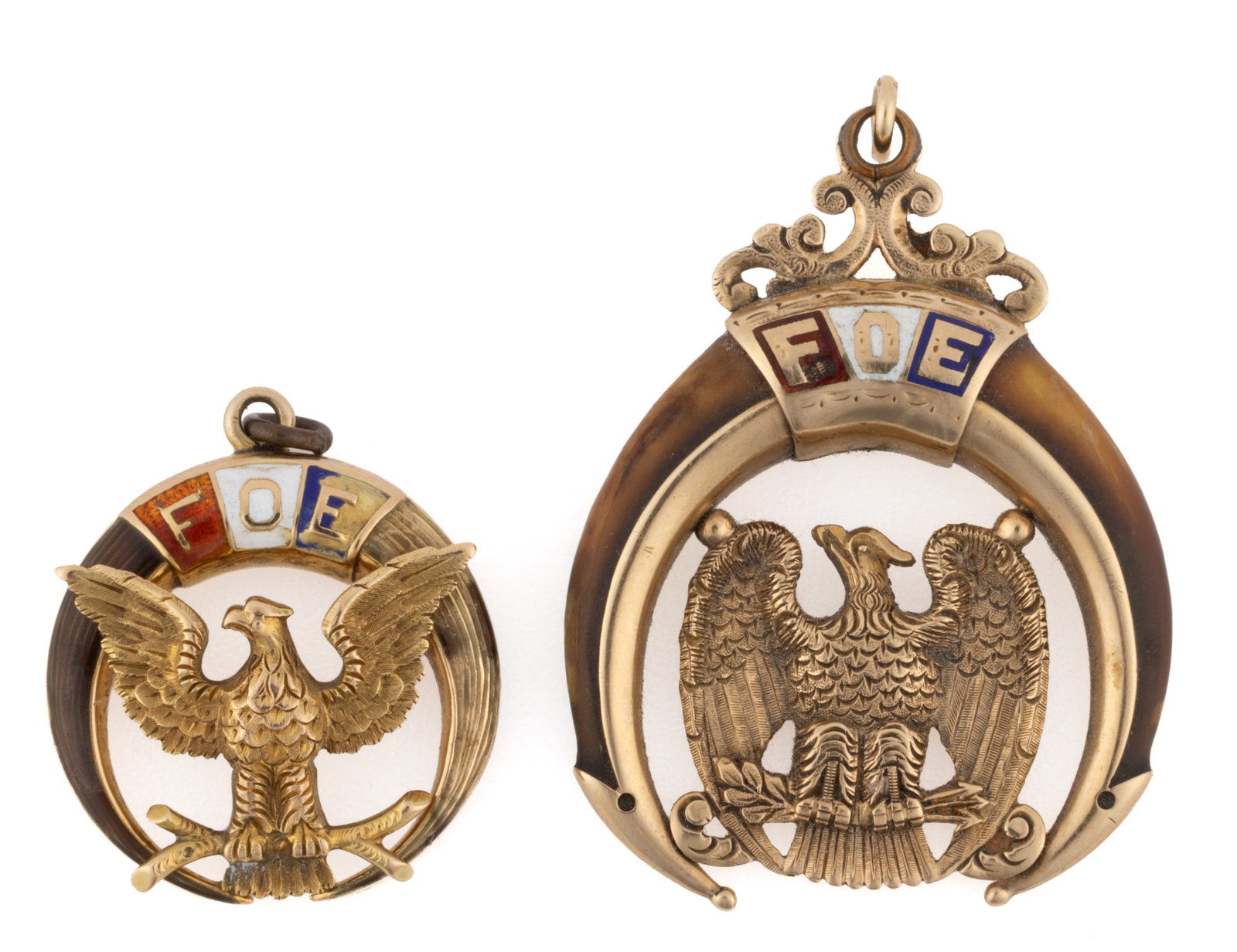ANTIQUE / VINTAGE GOLD / GOLD-FILLED, ENAMEL, AND CLAW-TYPE FRATERNAL ORDER OF EAGLES (F.O.E.) WATCH: ANTIQUE / VINTAGE GOLD / GOLD-FILLED, ENAMEL, AND CLAW-TYPE FRATERNAL ORDER OF EAGLES (F.O.E.) WATCH FOBS / PENDANTS, LOT OF TWO, each with central enameled "FOE" initials, encompassing a sp