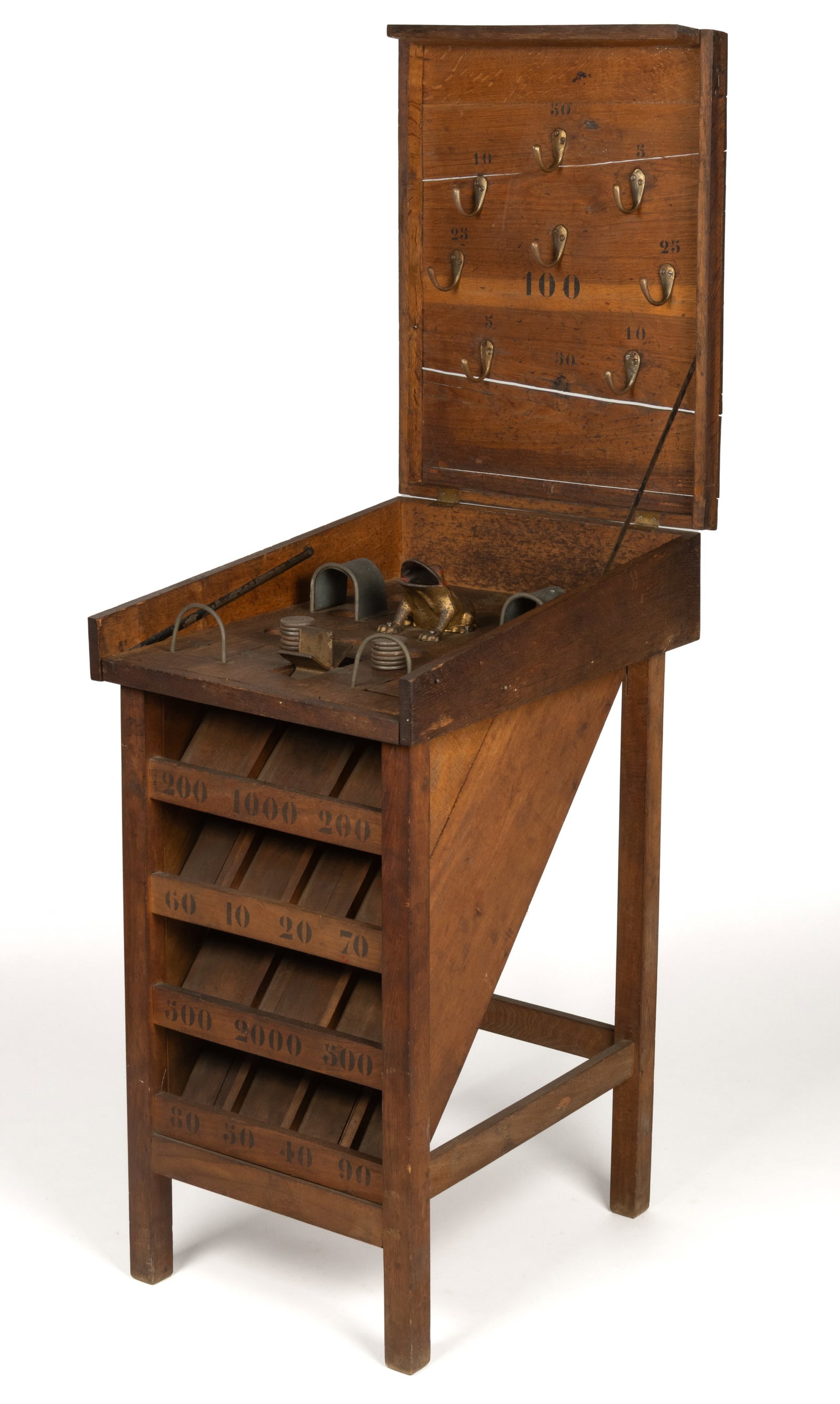 AMERICAN CARNIVAL / CIRCUS COIN-TOSS GAME WITH FROG: AMERICAN CARNIVAL / CIRCUS COIN-TOSS GAME WITH FROG, the free-standing oak form with hinged cover bearing prize hooks to underside, painted cast-iron components to playing surface, including open