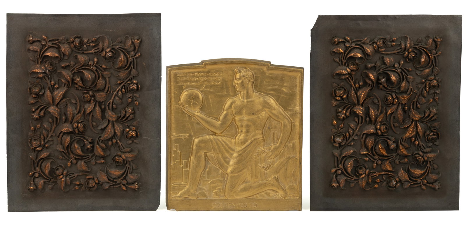 ASSORTED METAL DECORATIVE BAS-RELIEF PLAQUES, LOT OF THREE: ASSORTED METAL DECORATIVE BAS-RELIEF PLAQUES, LOT OF THREE, comprising a pair of matching floral panels; and a B. F. Goodrich presentation plaque featuring Atlas with an Art Deco theme. Late