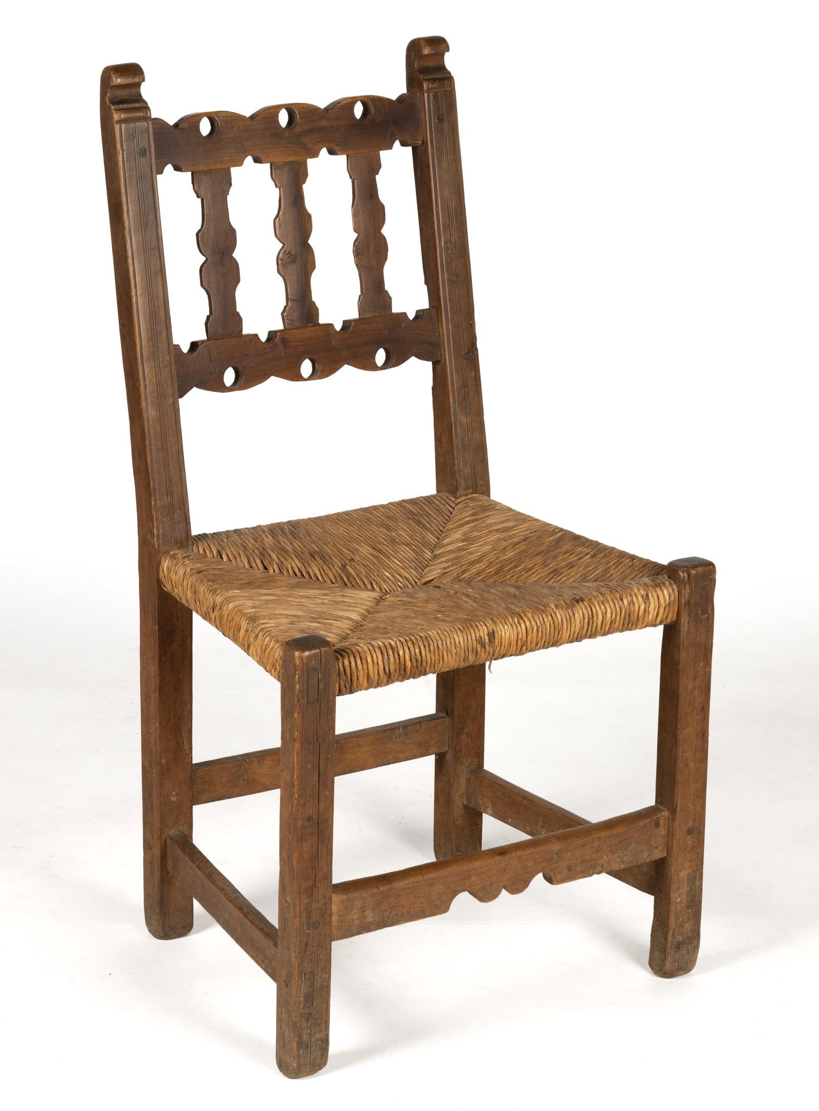 AMERICAN OR MEXICAN SPANISH COLONIAL SIDE CHAIR: AMERICAN OR MEXICAN SPANISH COLONIAL SIDE CHAIR, featuring a shaped banister back supported by two slanted rear posts topped with carved hook-like finials, over a trapezoidal rush seat, the whole