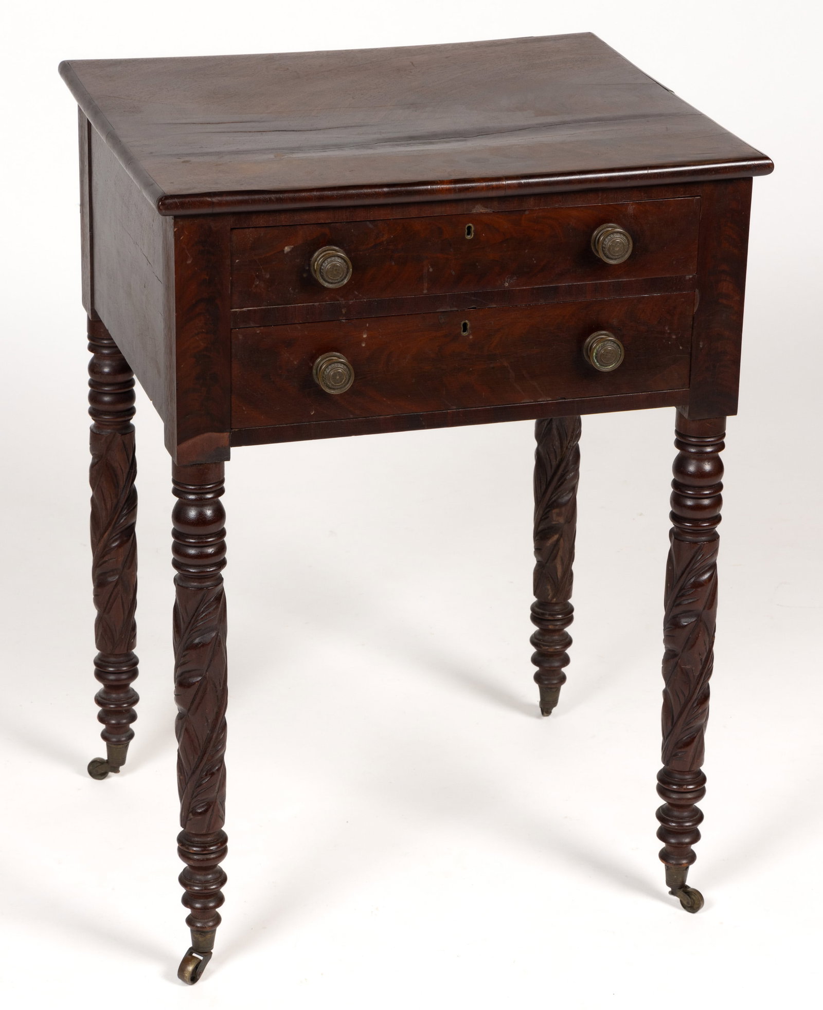 LATE FEDERAL MAHOGANY VENEERED TWO-DRAWER WORK STAND: LATE FEDERAL MAHOGANY VENEERED TWO-DRAWER WORK STAND, the overhanging rectangular top over two drawers retaining their original pulls, the whole raised on turned legs with foliate carved