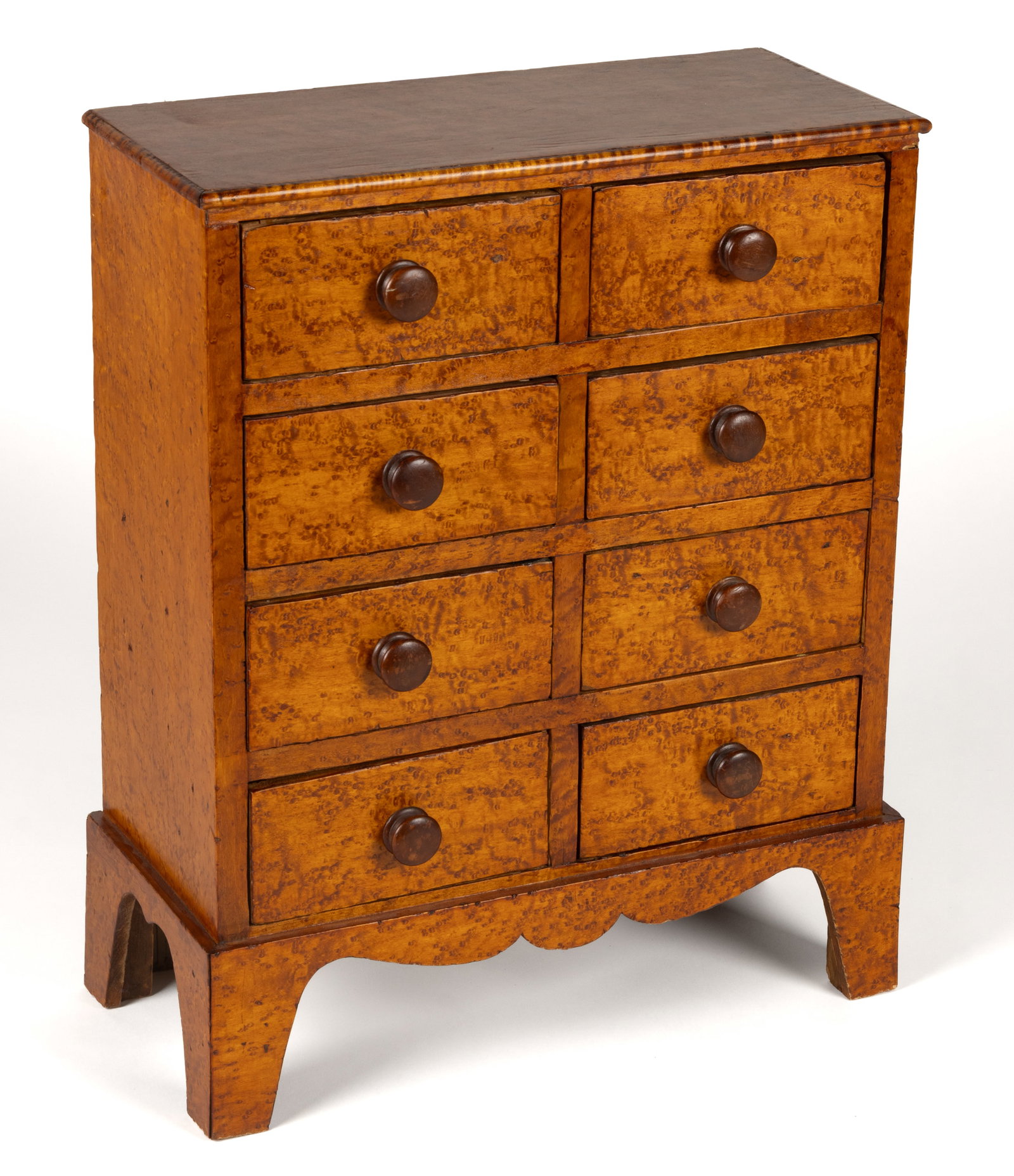 AMERICAN BENCH-MADE BIRD'S EYE MAPLE-VENEERED DIMINUTIVE / CHILD'S CHEST OF DRAWERS: AMERICAN BENCH-MADE BIRD'S EYE MAPLE-VENEERED DIMINUTIVE / CHILD'S CHEST OF DRAWERS, made, at least in part, from old wood, the rectangular top with a molded edge over eight short drawers