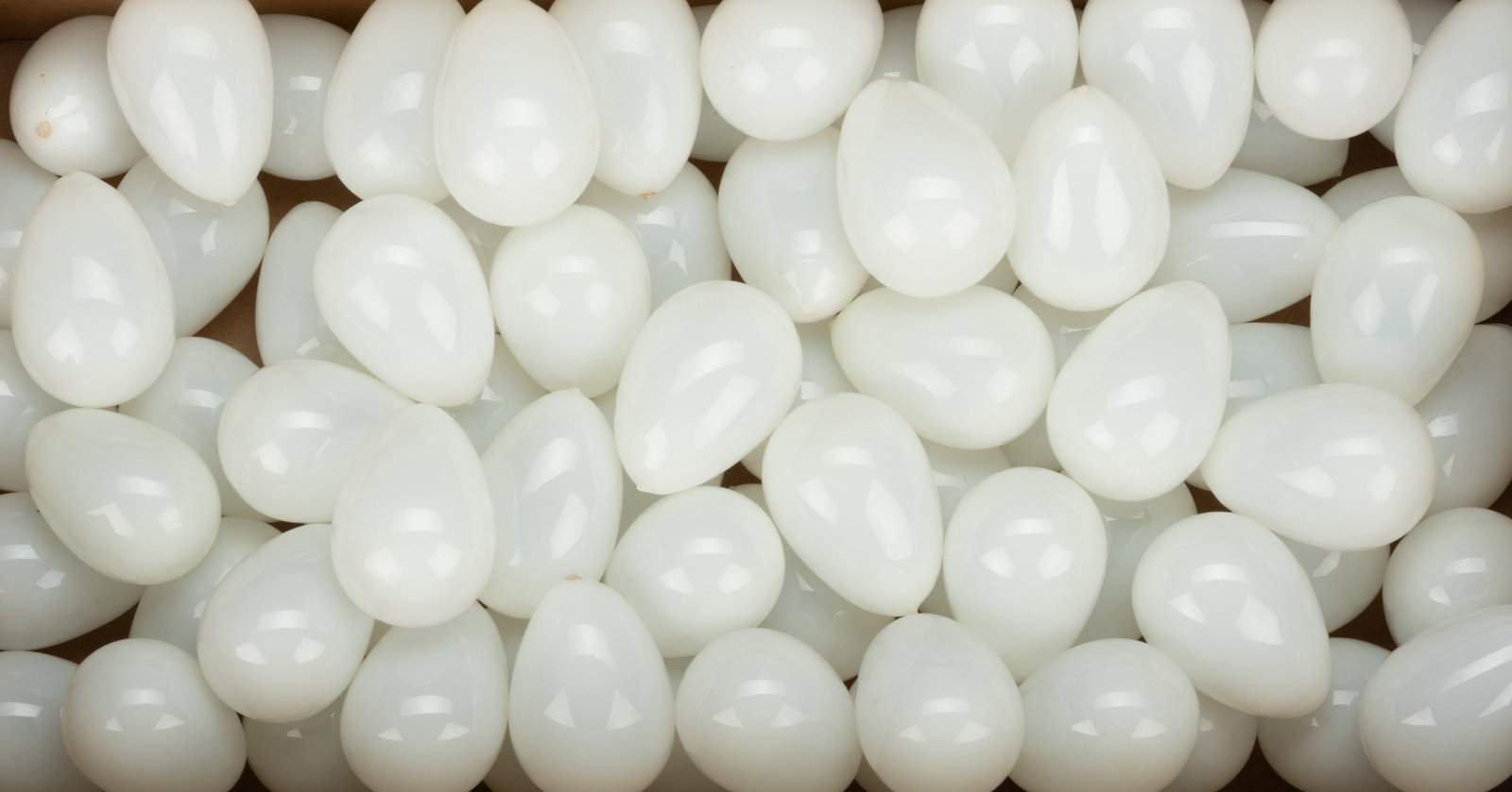 BLOWN GLASS EGGS, LOT OF 75: BLOWN GLASS EGGS, LOT OF 75, opal, each being chicken-sized, each with a rough pontil mark. 19th century. Approximately 2 1/2" to 2 5/8" LOA.