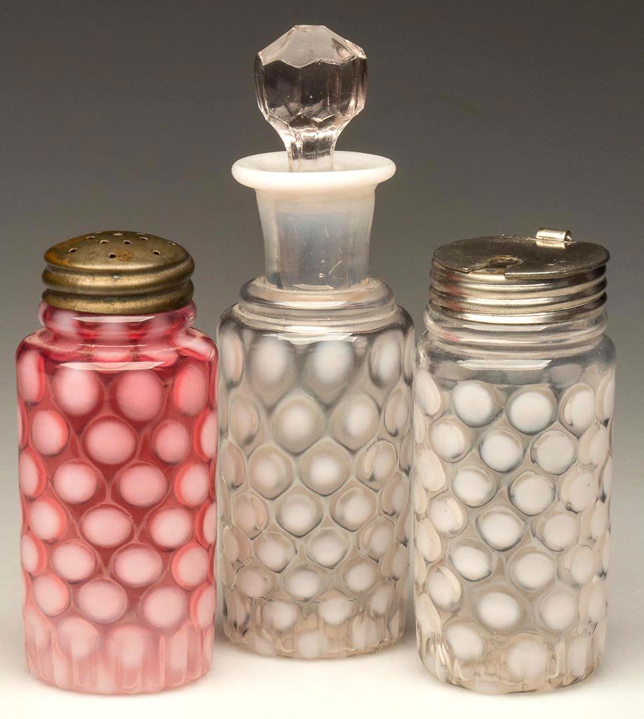 COINSPOT ASSEMBLED THREE-PIECE CONDIMENT SET: COINSPOT ASSEMBLED THREE-PIECE CONDIMENT SET, colorless and cranberry opalescent, each with a 1/2" band of ribbing around the base, comprising a salt shaker and a mustard with period lids, and an oil