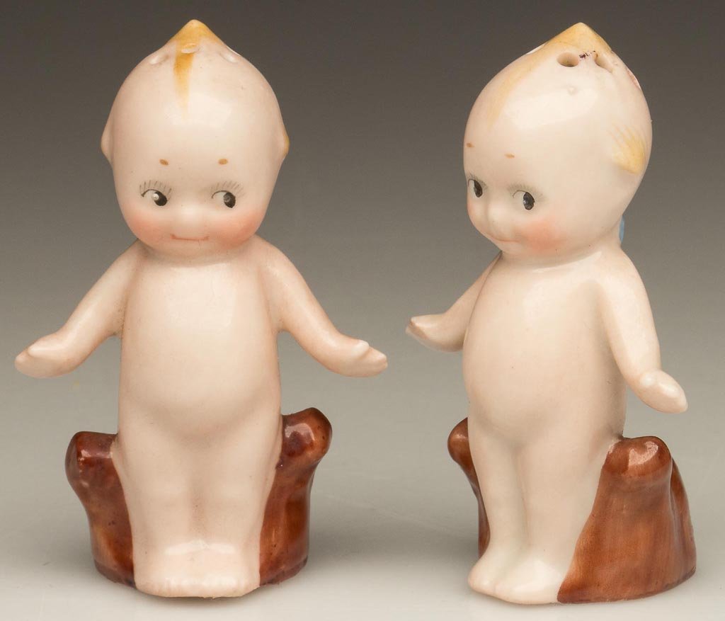 ROSE O'NEILL KEWPIE CERAMIC PAIR OF SALT AND PEPPER SHA: ROSE O'NEILL KEWPIE CERAMIC PAIR OF SALT AND PEPPER SHAKERS, opaque white with nude ground, each retains original paper label marked "KEWPIE.REG.U.S-PAT.OFF / DES PAT.III.4.1913" and later cork stoppe