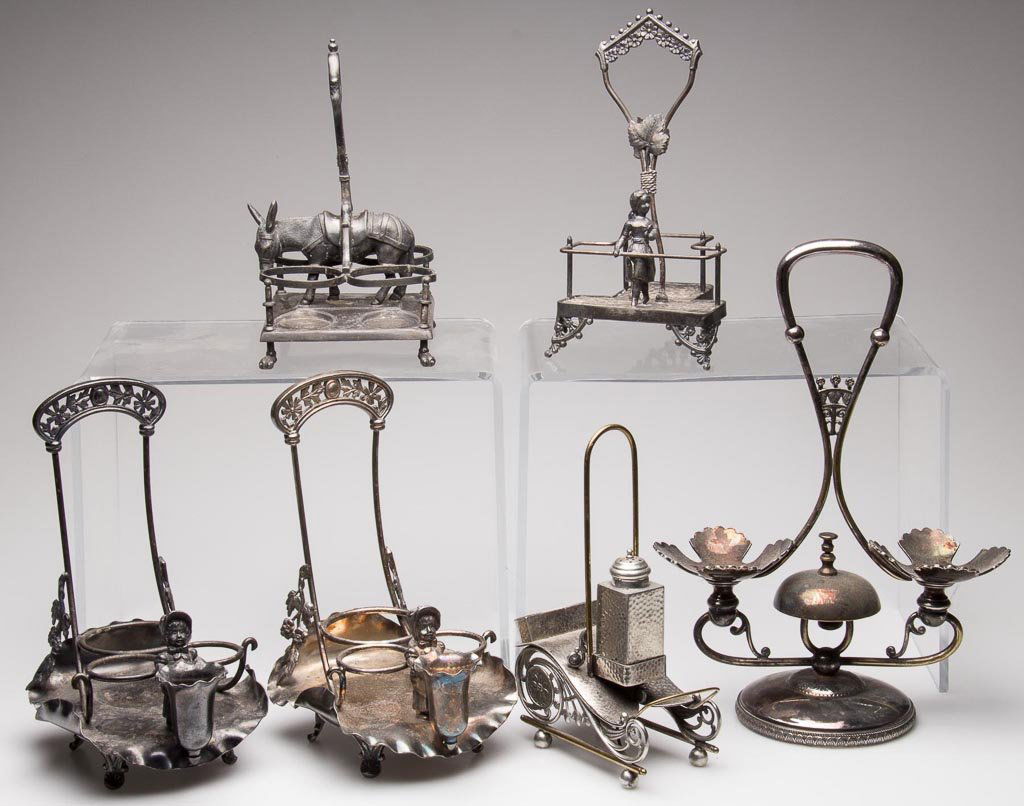 VICTORIAN QUADRUPLE-PLATE FIGURAL STANDS, LOT OF SIX: VICTORIAN QUADRUPLE-PLATE FIGURAL STANDS, LOT OF SIX, including two with Kate Greenaway figures holding toothpick holders, and one with a bell, manufacturer's marks include Wilcox, Reed & Barton, and