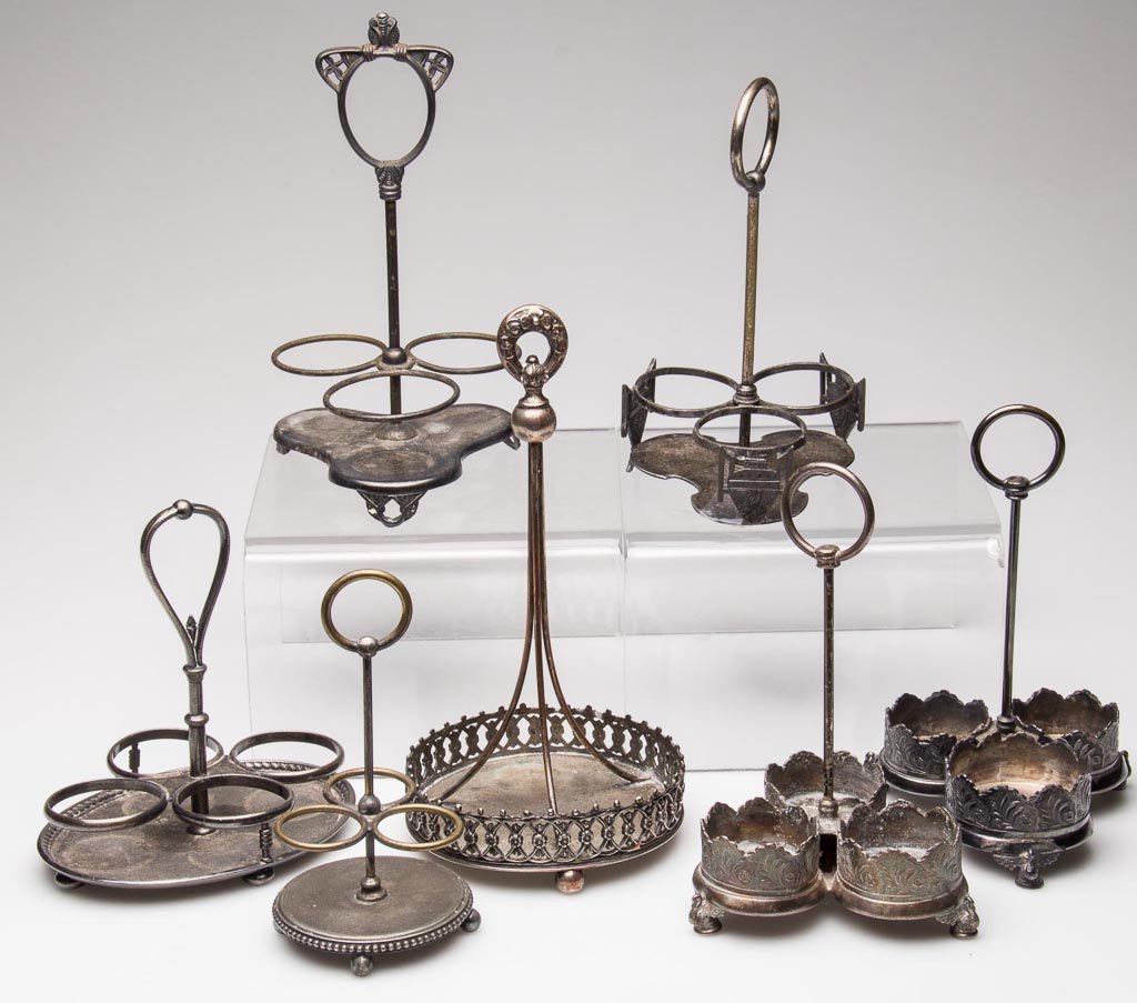 VICTORIAN QUADRUPLE-PLATE THREE-BOTTLE STANDS, LOT OF S: VICTORIAN QUADRUPLE-PLATE THREE-BOTTLE STANDS, LOT OF SEVEN, manufacturer's marks include Pairpoint, Wilcox, Rogers and Reed & Barton. Fourth quarter 19th/early 20th century. 5 1/2" to 8 1/2" HOA. Pro