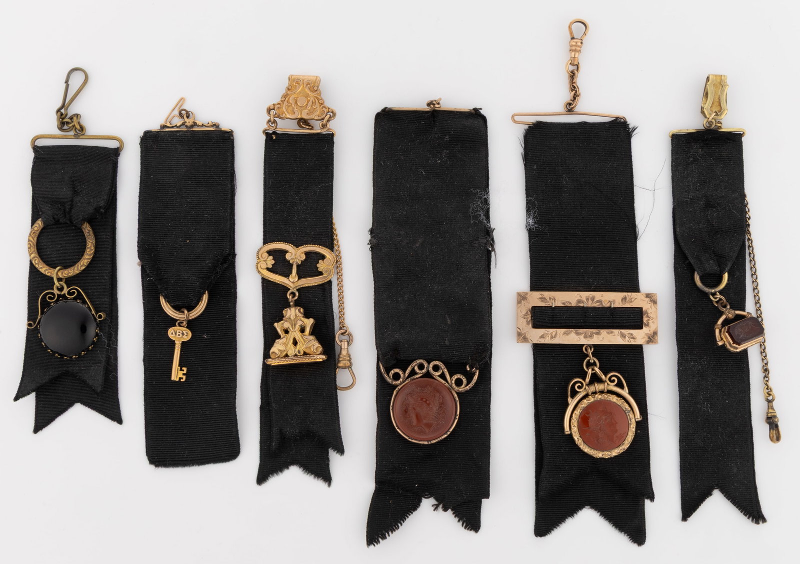 ANTIQUE / VICTORIAN POCKET WATCH FOBS, LOT OF SIX: ANTIQUE / VICTORIAN POCKET WATCH FOBS, LOT OF SIX, each black grosgrain silk fitted with gold-filled mounts, three with classical carnelian intaglio fobs, two being swivel style. Fourth quar