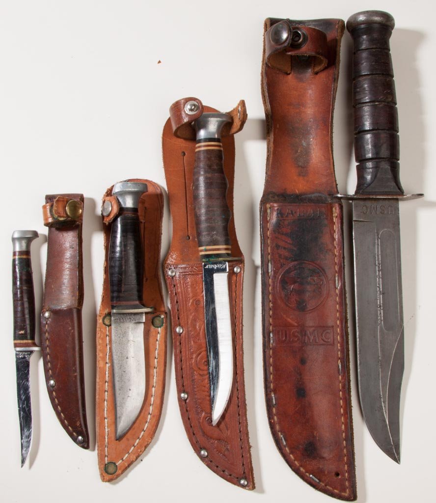 KA-BAR HUNTING AND FIGHTING KNIVES, LOT OF FOUR: KA-BAR HUNTING AND FIGHTING KNIVES, LOT OF FOUR, fixed blades comprising three leather handle with nickel-silver bolster and a wooden handle example with blade marked "USMC", each fitted in a leather