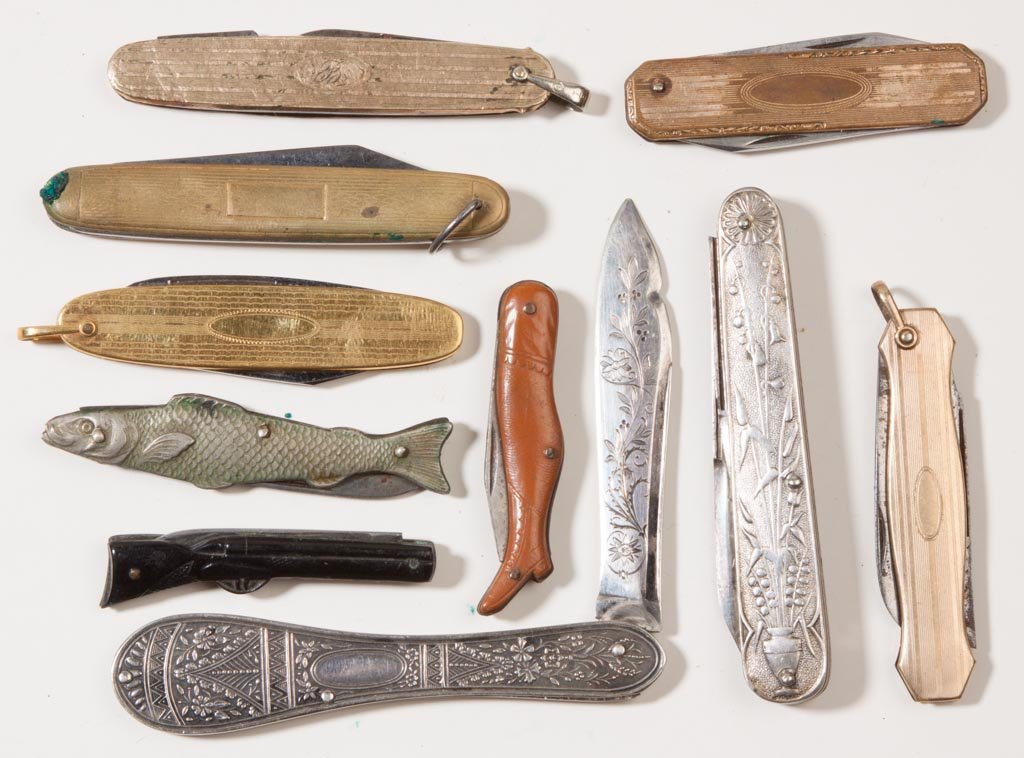 VARIOUS MATERIALS POCKET KNIVES, LOT OF TEN: VARIOUS MATERIALS POCKET KNIVES, LOT OF TEN, comprising three figural examples, including a synthetic boot and Germania rifle, a M. C. Co. fish with silver-like finish; three gold-filled examples incl