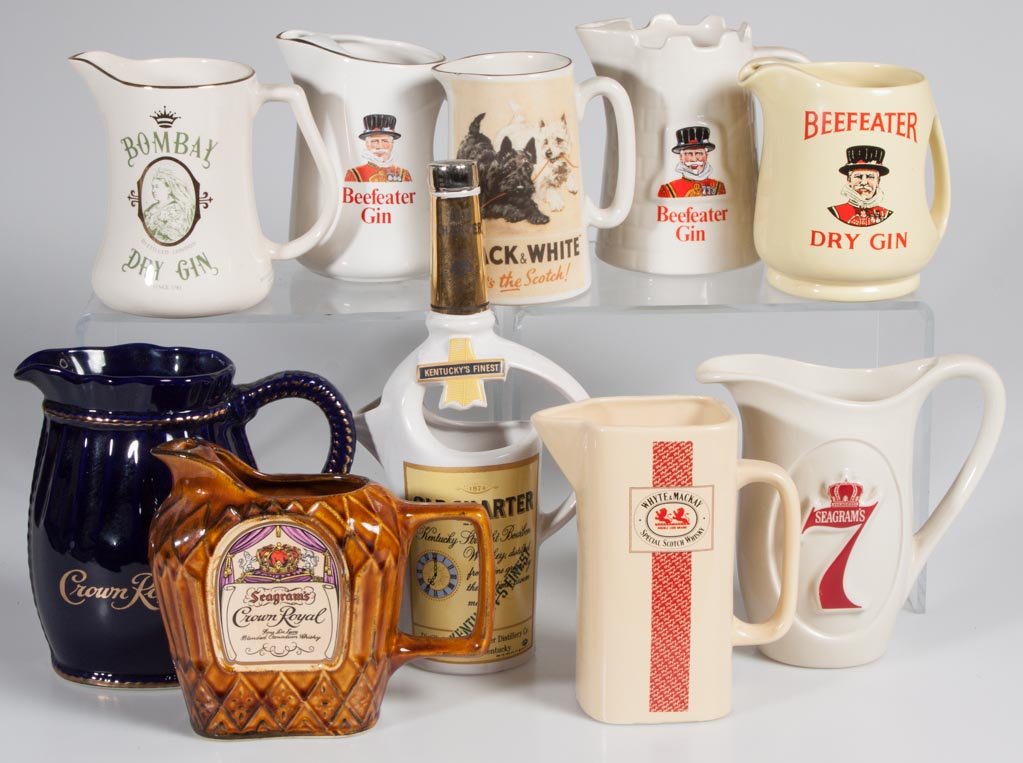 ASSORTED WHISKEY AND GIN CERAMIC ADVERTISING PITCHERS,: ASSORTED WHISKEY AND GIN CERAMIC ADVERTISING PITCHERS, LOT OF TEN, including Bombay, Beefeater, Crown Royal and Old Charter. 20th century. 5 1/4" to 12" H. Provenance: From a Connecticut private colle