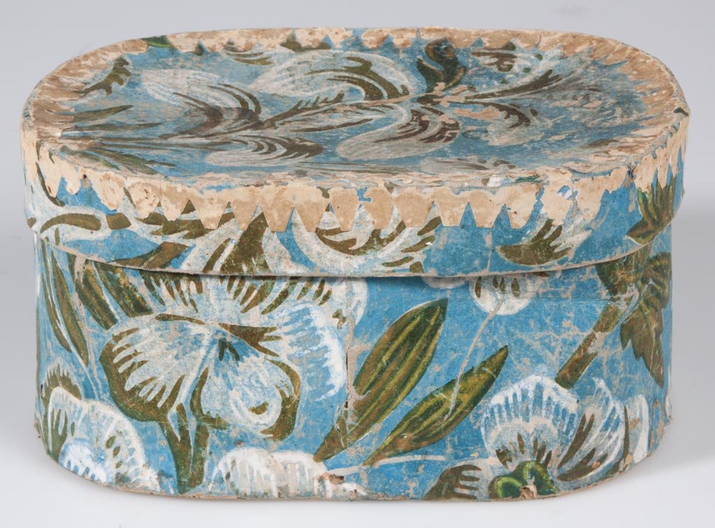 SHENANDOAH VALLEY OF VIRGINIA WALLPAPER-COVERED BOX: SHENANDOAH VALLEY OF VIRGINIA WALLPAPER-COVERED BOX, oblong form with printed flowers and leaves, interior lined with paper from an almanac printed in German. Probably Augusta Co. First quarter 19th c