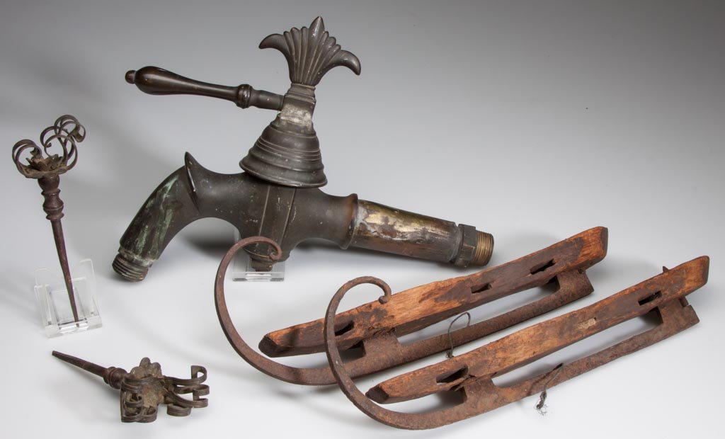 ASSORTED DOMESTIC ARTICLES, LOT OF FIVE: ASSORTED DOMESTIC ARTICLES, LOT OF FIVE, comprising a heavy brass spigot, a pair of wrought-iron and wood ice skates, and a pair of brass and wrought-iron shutter pins. 19th and early 20th century. Sp