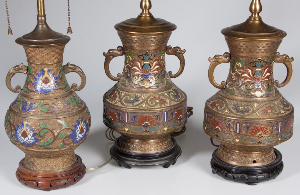 JAPANESE BRONZE AND CHAMPLEVE ENAMEL TABLE LAMPS, LOT O: JAPANESE BRONZE AND CHAMPLEVE ENAMEL TABLE LAMPS, LOT OF THREE, adapted from two-handle urns. 20th century. 22" to 26" HOA. Provenance: The estate collection of Richard and Betty Robertson, Waynesboro