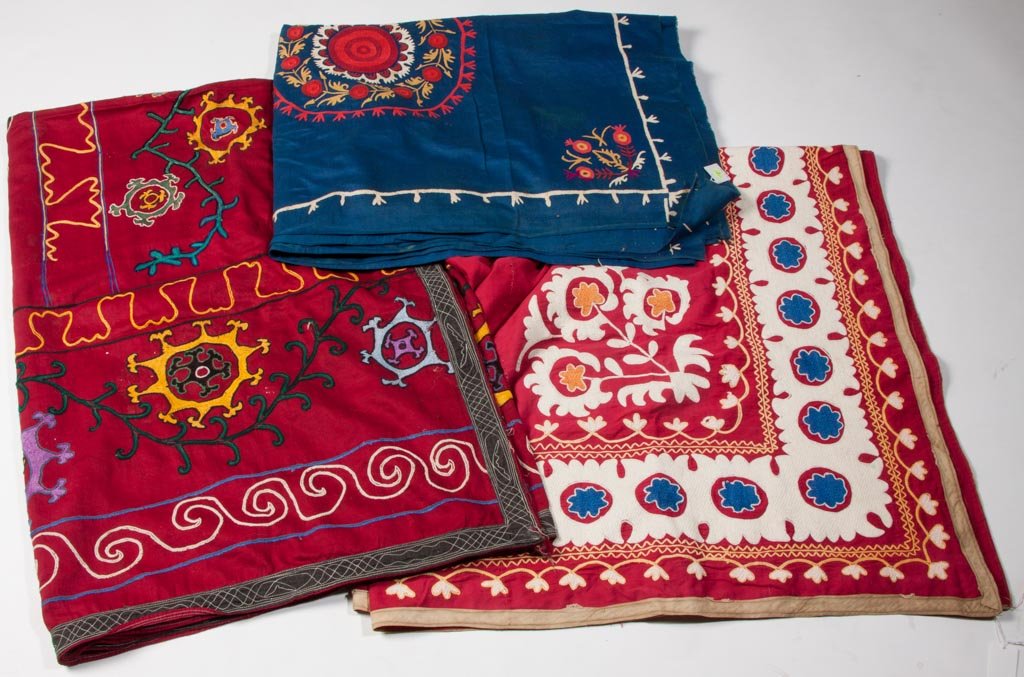 CENTRAL ASIAN EMBROIDERED SUZANI TEXTILES, LOT OF THREE: CENTRAL ASIAN EMBROIDERED SUZANI TEXTILES, LOT OF THREE, three-joined panels, comprising two with red ground, including an example with floral pattern border and other with overall stylized medallions