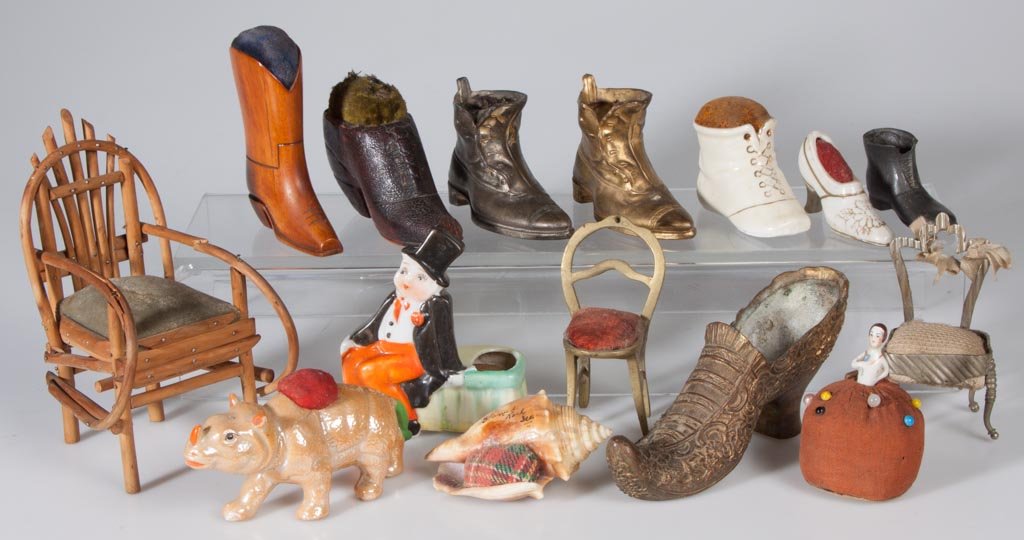ASSORTED FIGURAL PIN CUSHIONS, LOT OF 15: ASSORTED FIGURAL PIN CUSHIONS, LOT OF 15, various metals, china, wood and shell. Late 19th/first half 20th century. 1 3/4" to 5 3/4" H. Provenance: From an Illinois private collection. Circa:Late 19th