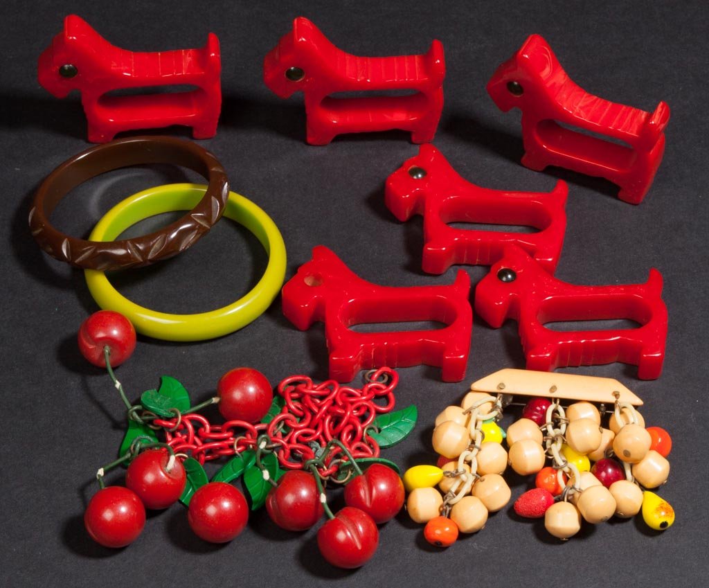 VINTAGE BAKELITE ARTICLES, LOT OF TEN: VINTAGE BAKELITE ARTICLES, LOT OF TEN, comprising a fruit broach, a necklace, two bangle bracelets, and a set of six Scotty Dog napkin rings. Mid-20th century. Various sizes. Provenance: The estate co